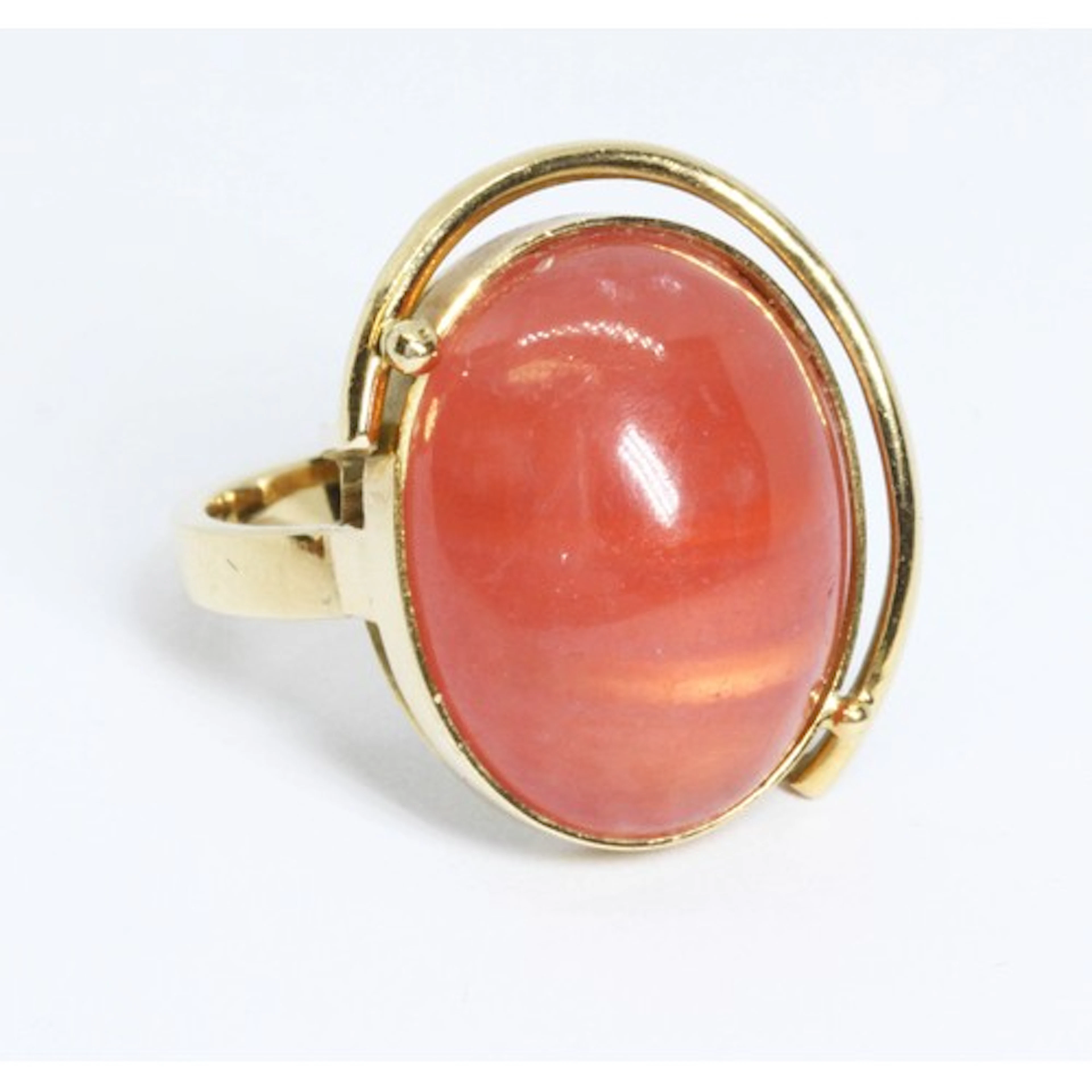 A rhodochrosite cabochon ring, the bezel set orangy pink tra...