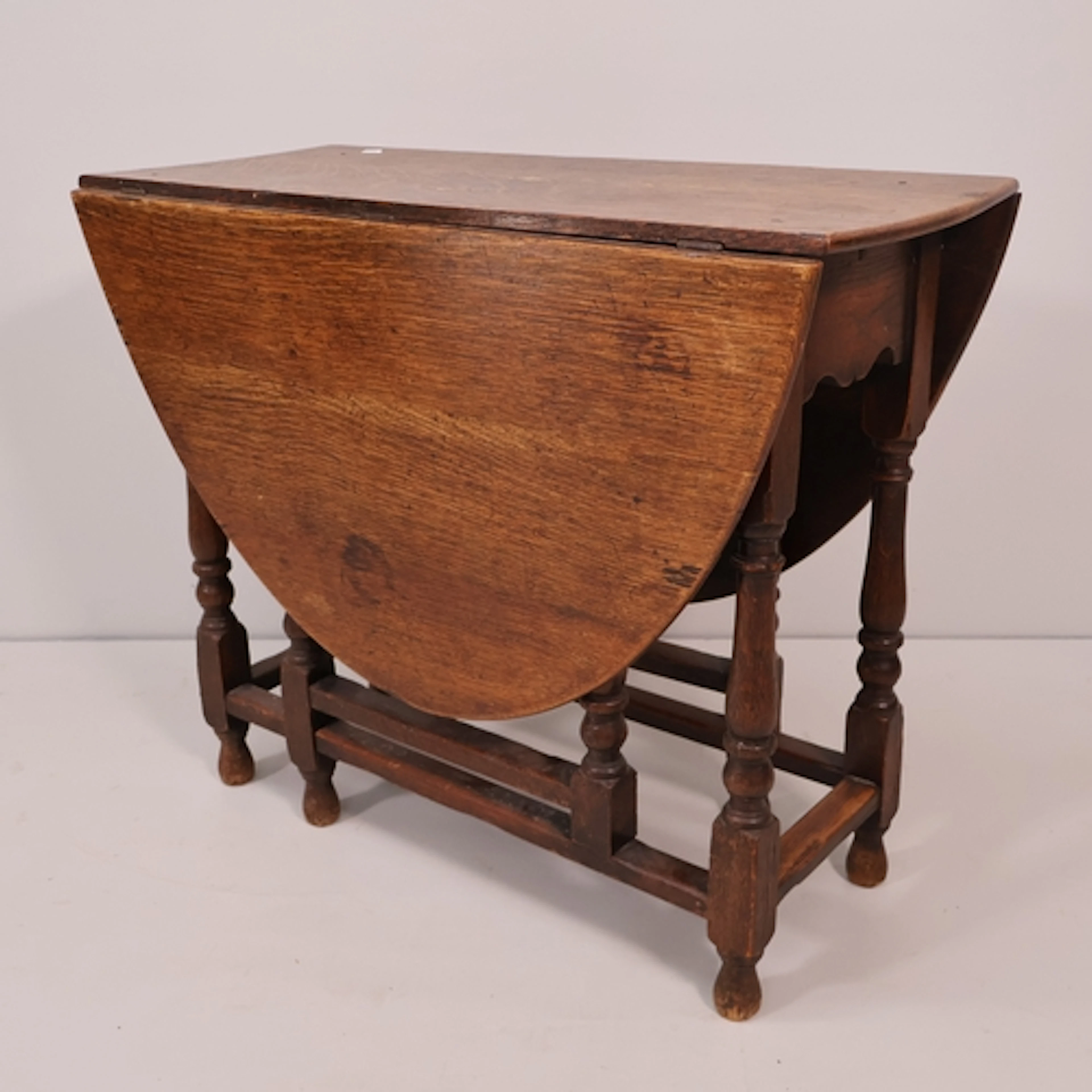 An antique oak oval gateleg table, W86cm, H73cm, D39cm.
