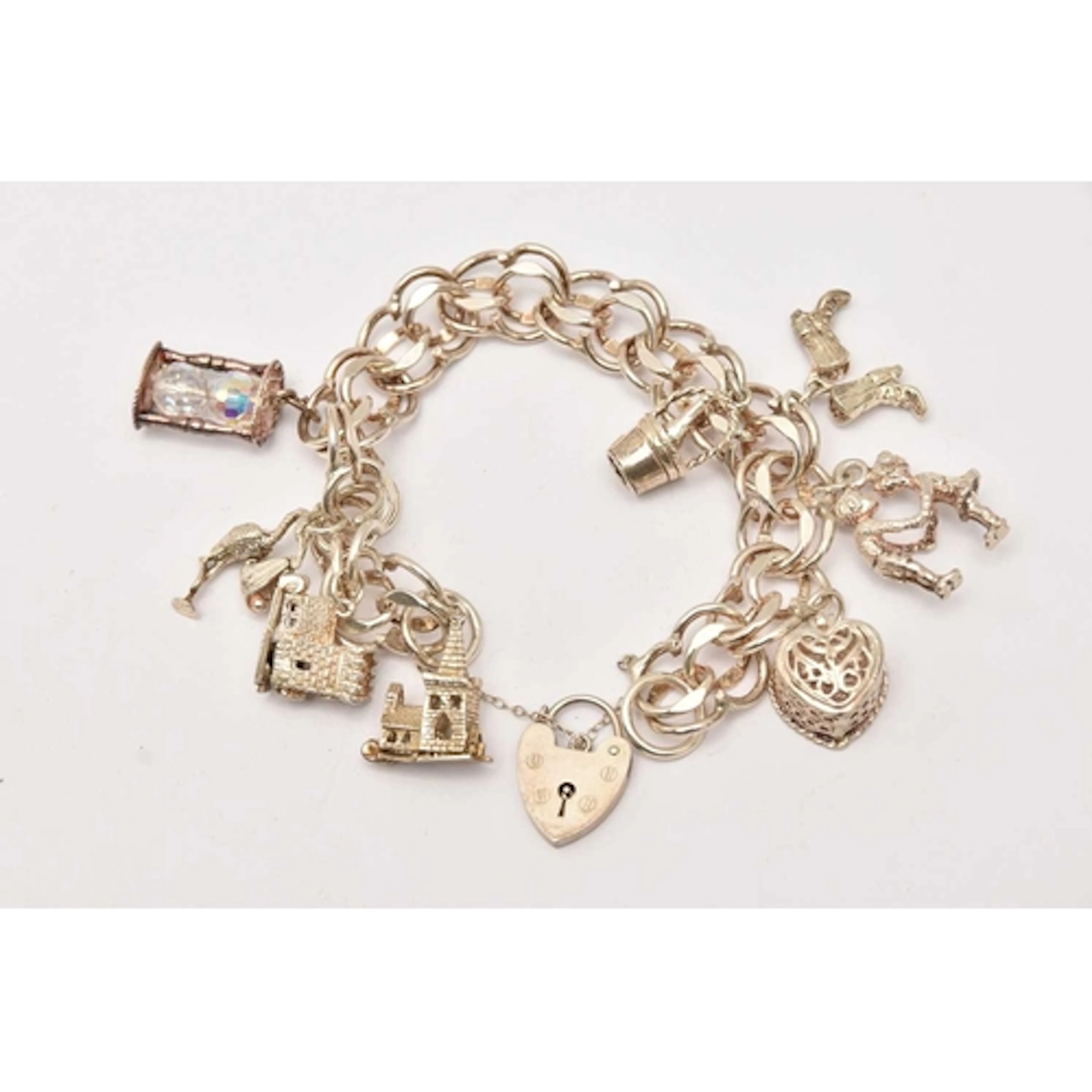 A SILVER CHARM BRACELET, double link bracelet, fitted with a...