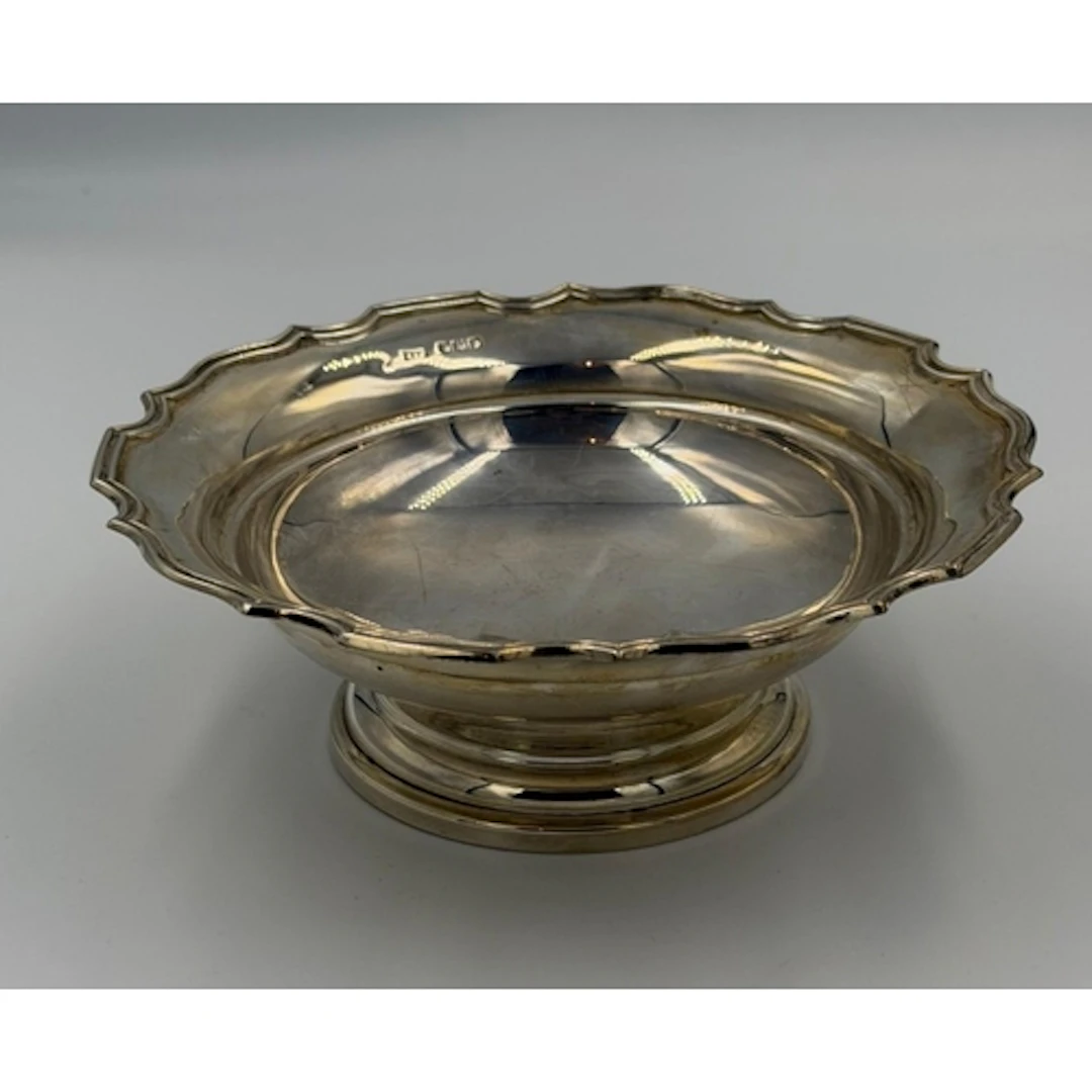 A scalloped edged silver bowl on a single foot, hallmarked f...