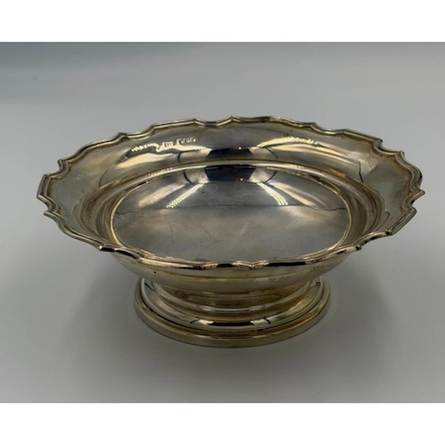 A scalloped edged silver bowl on a single foot, hallmarked f...