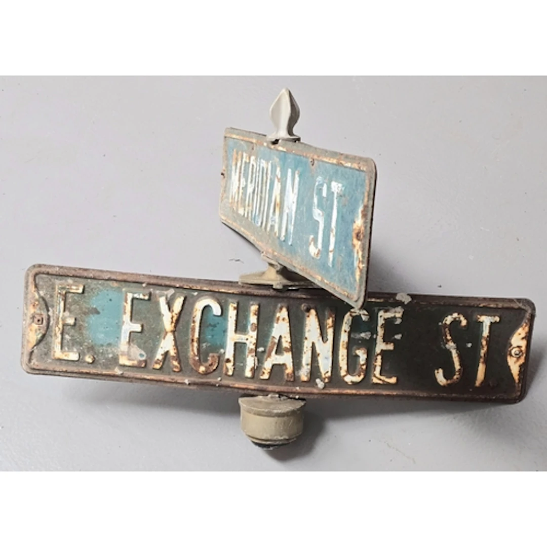 A vintage American street sign top featuring East Exchange S...