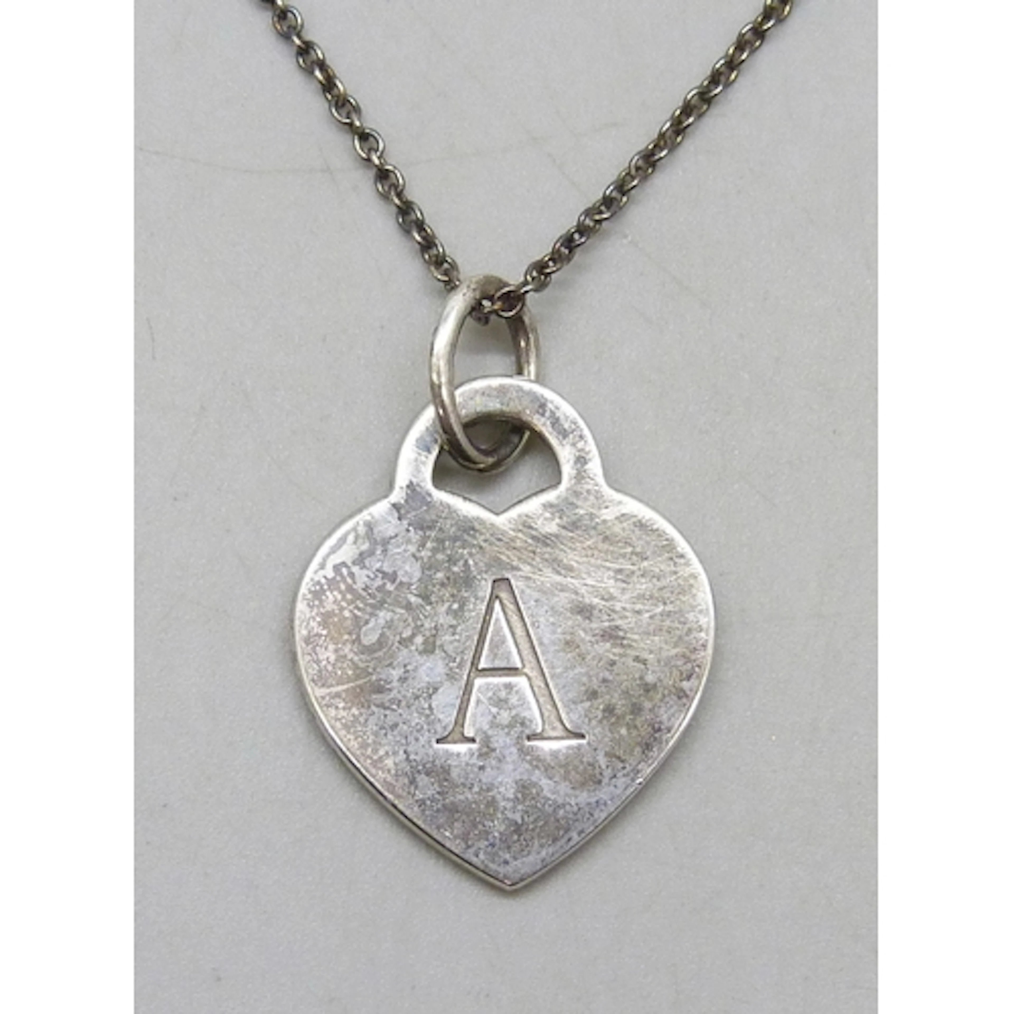A Tiffany & Co. New York silver heart tag pendant with initi...