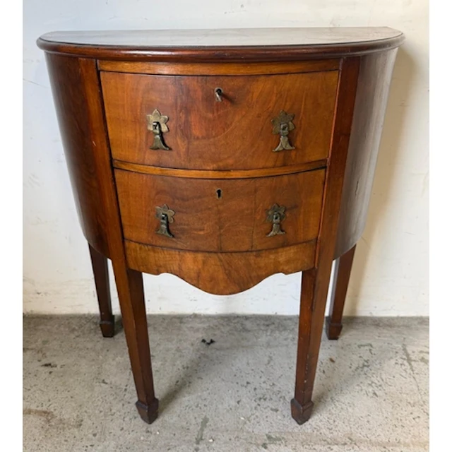 A demi-lune chest of dawers or side table with two cenral dr...