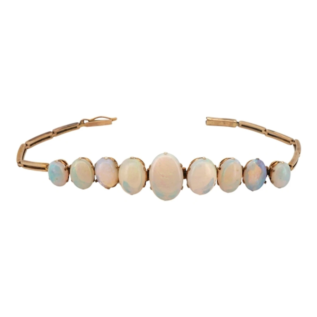 A yellow metal and nine stone graduated oval white opal set ...