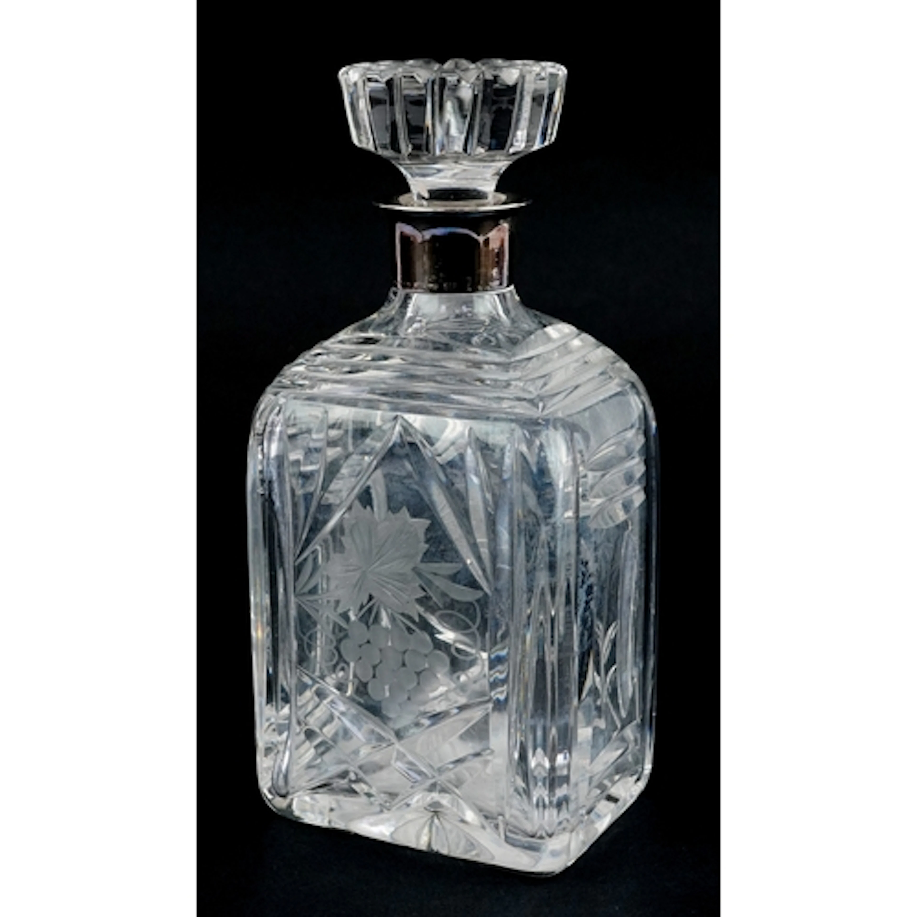 Cut crystal decanter etched with berries, having a silver co...