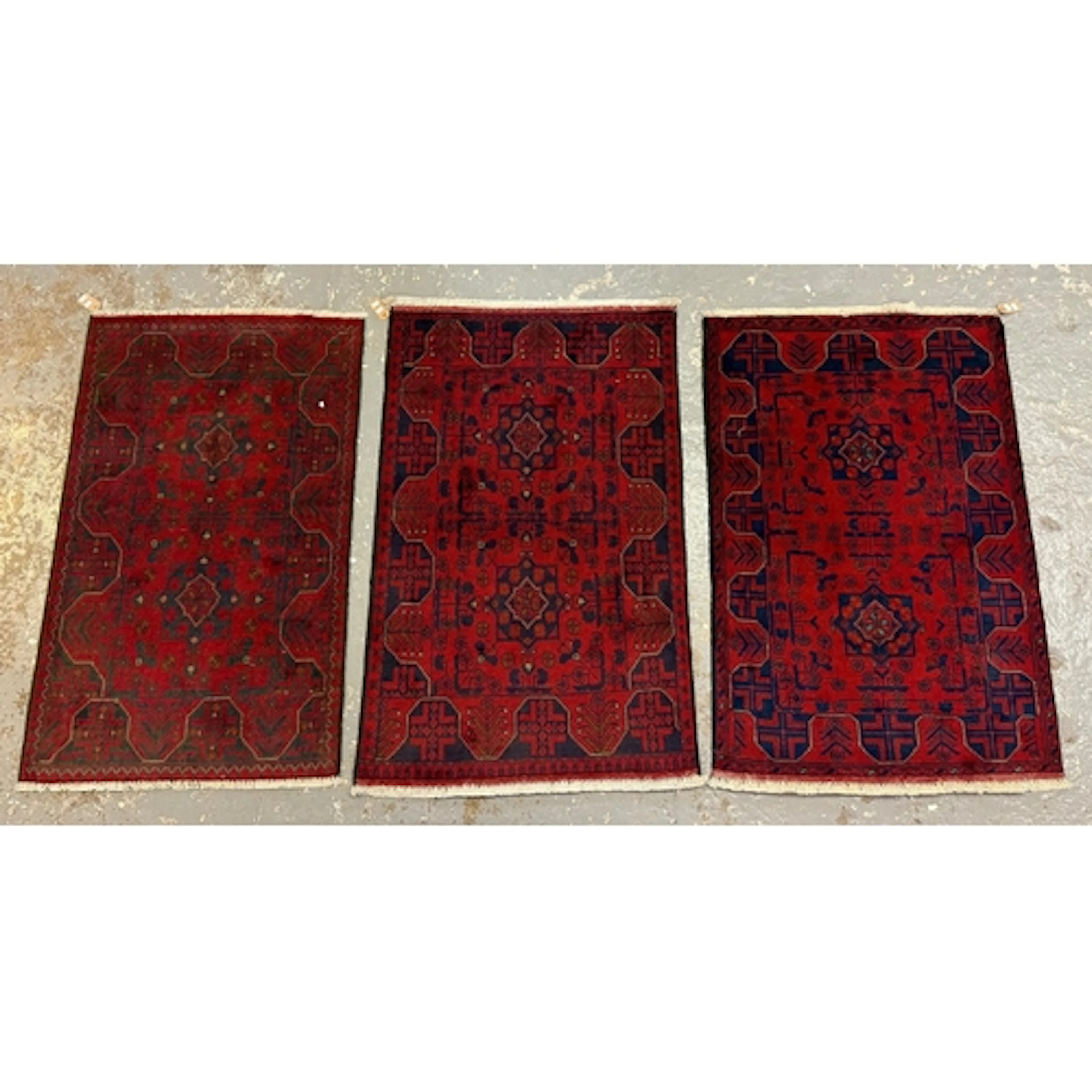 Three similar Pakistan hand knotted rugs, all on a red field...