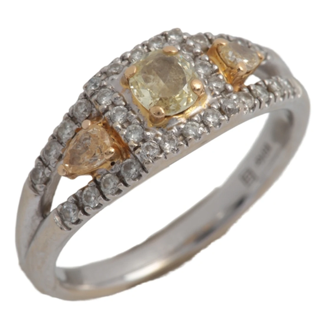 A yellow diamond and diamond ring, set with cushion- and pea...