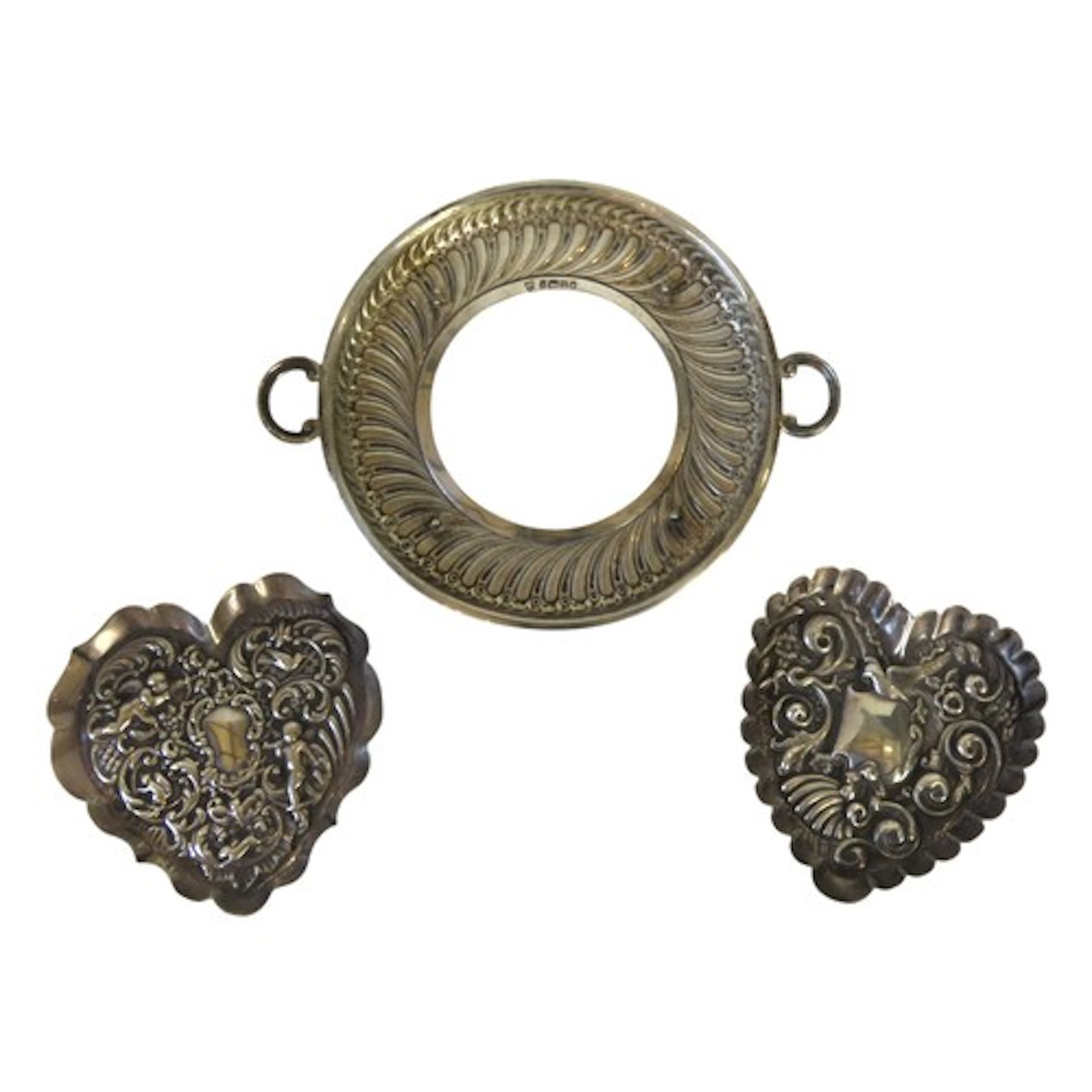 TWO EDWARDIAN SILVER HEART SHAPED REPOUSSE DISHES with putti...