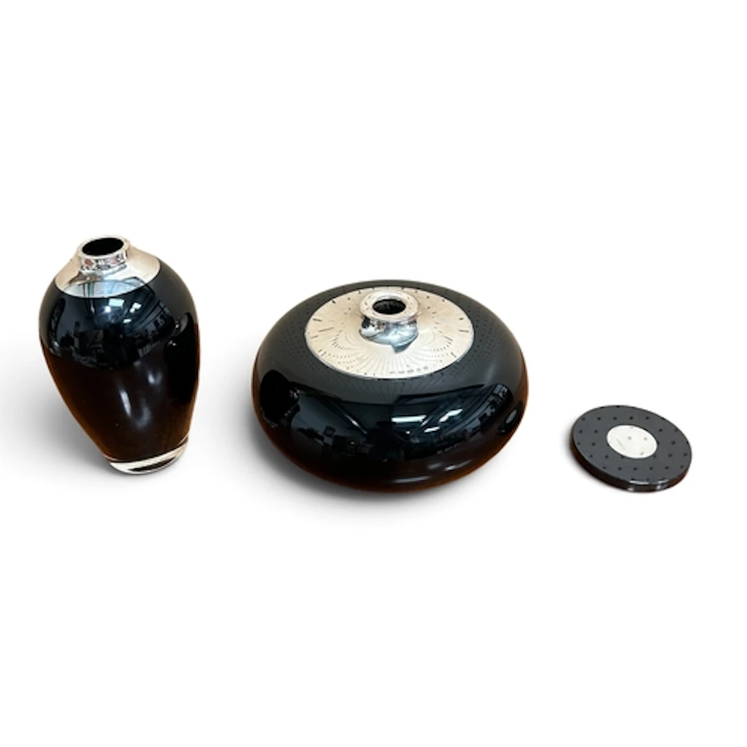 BRAYBOOK AND BRITTEN; A BLACK GLASS AND SILVER CURLING STONE...