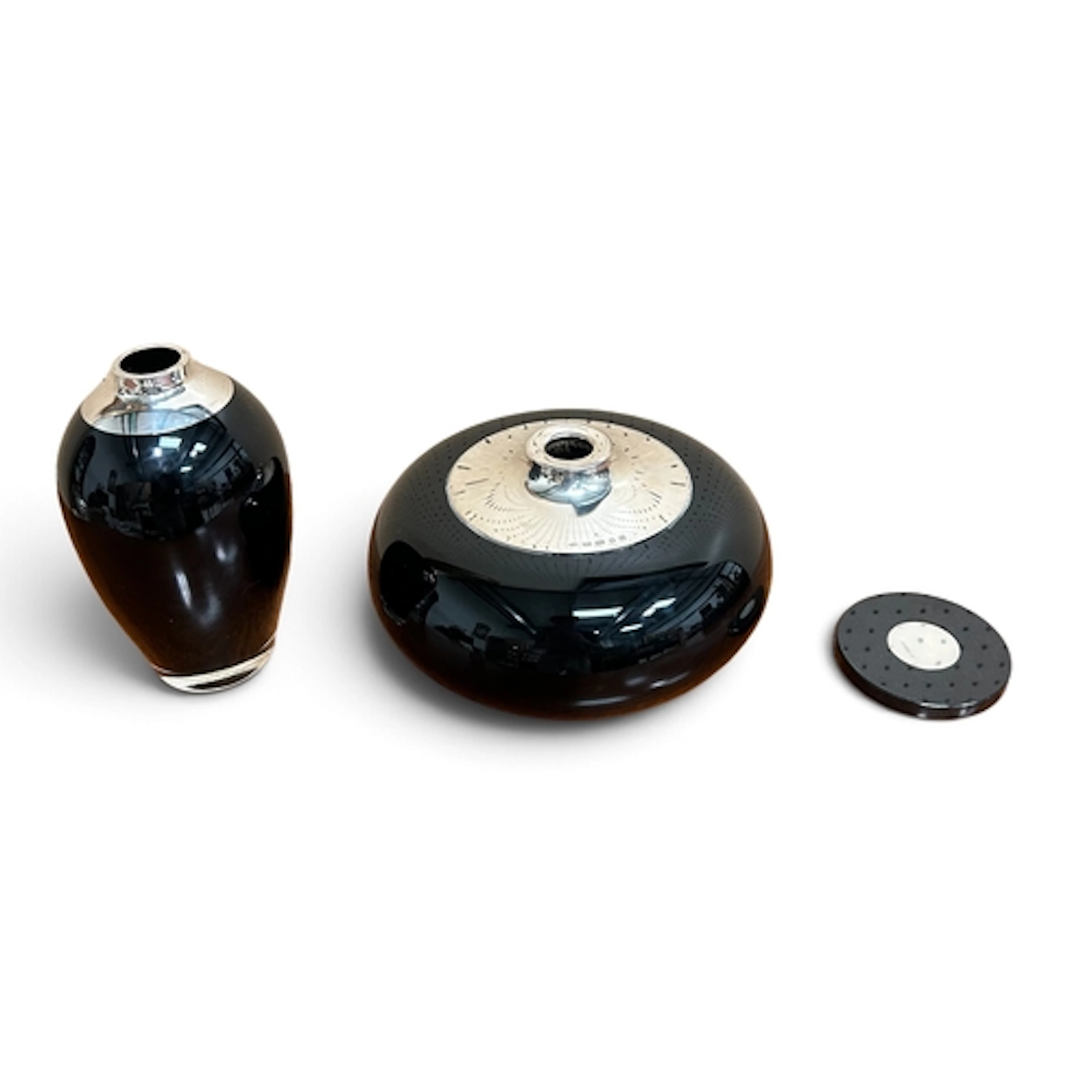 BRAYBOOK AND BRITTEN; A BLACK GLASS AND SILVER CURLING STONE...