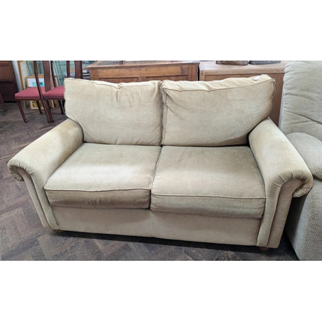 Modern two seater sofa upholstered in gold velour