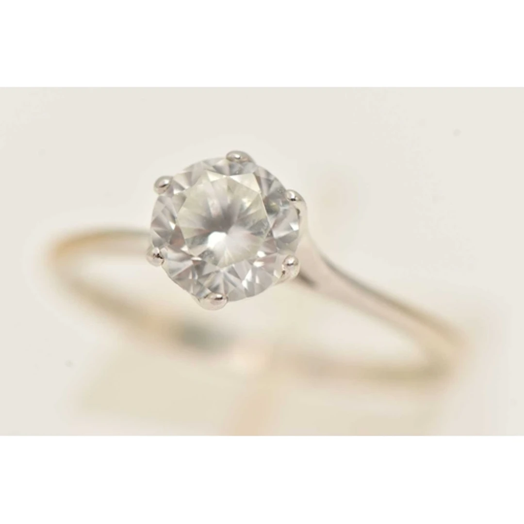 A WHITE METAL GEM SET RING, set with a circular cut colourle...