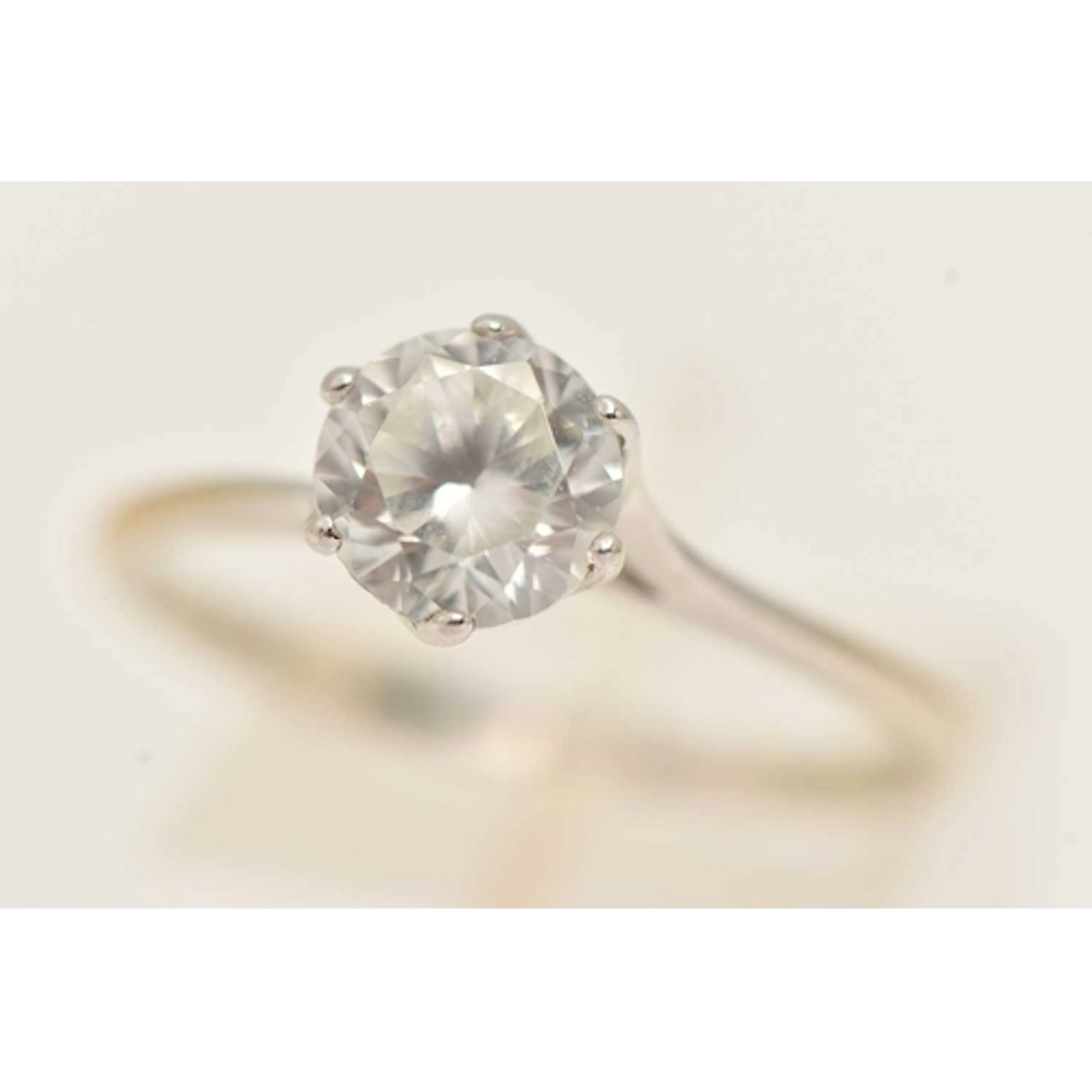 A WHITE METAL GEM SET RING, set with a circular cut colourle...