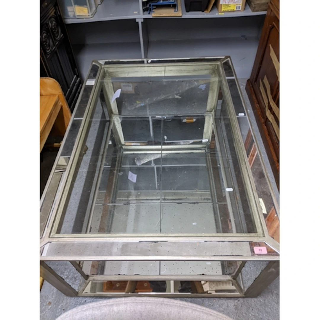 A silver coloured and mirrored glass two tier coffee table, ...