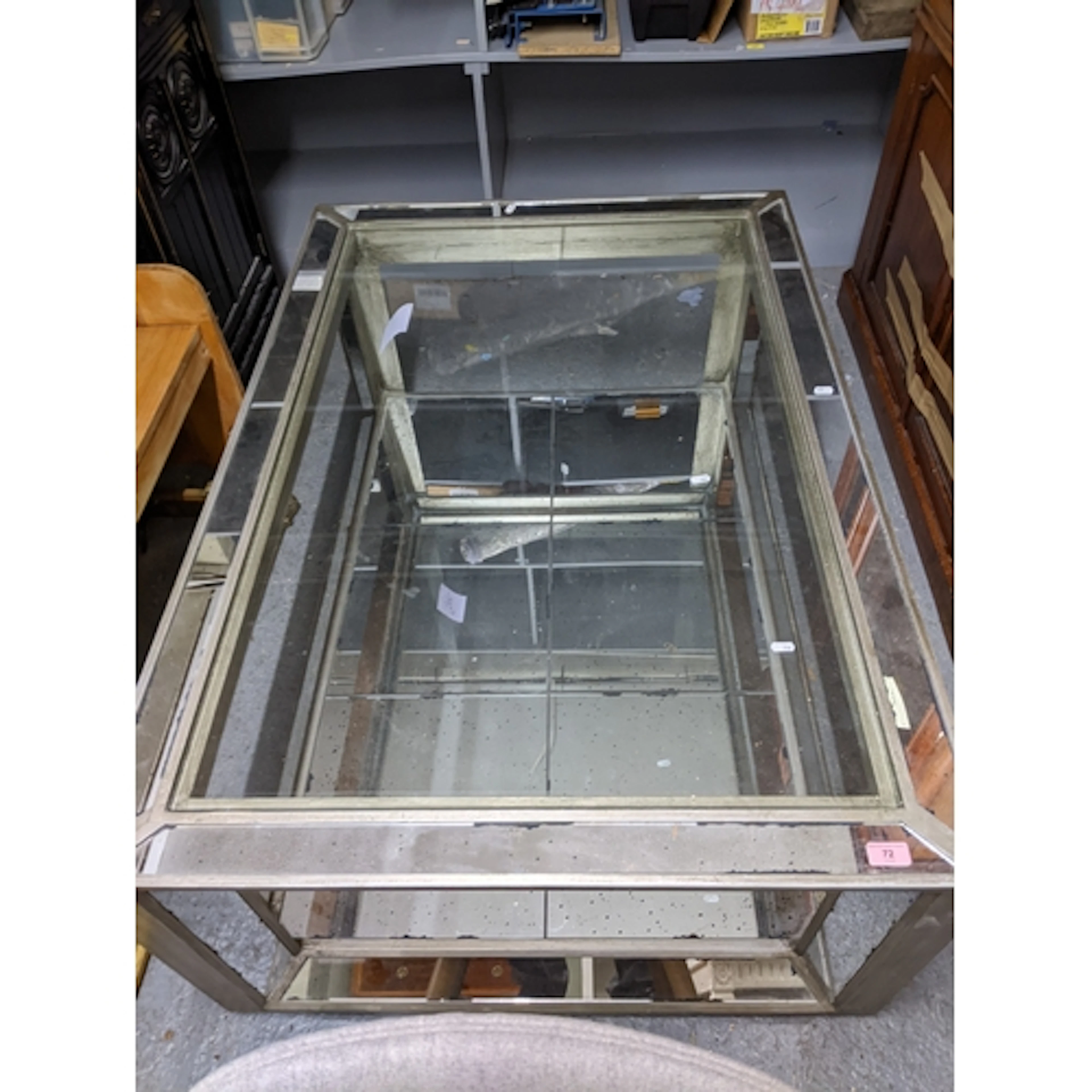 A silver coloured and mirrored glass two tier coffee table, ...