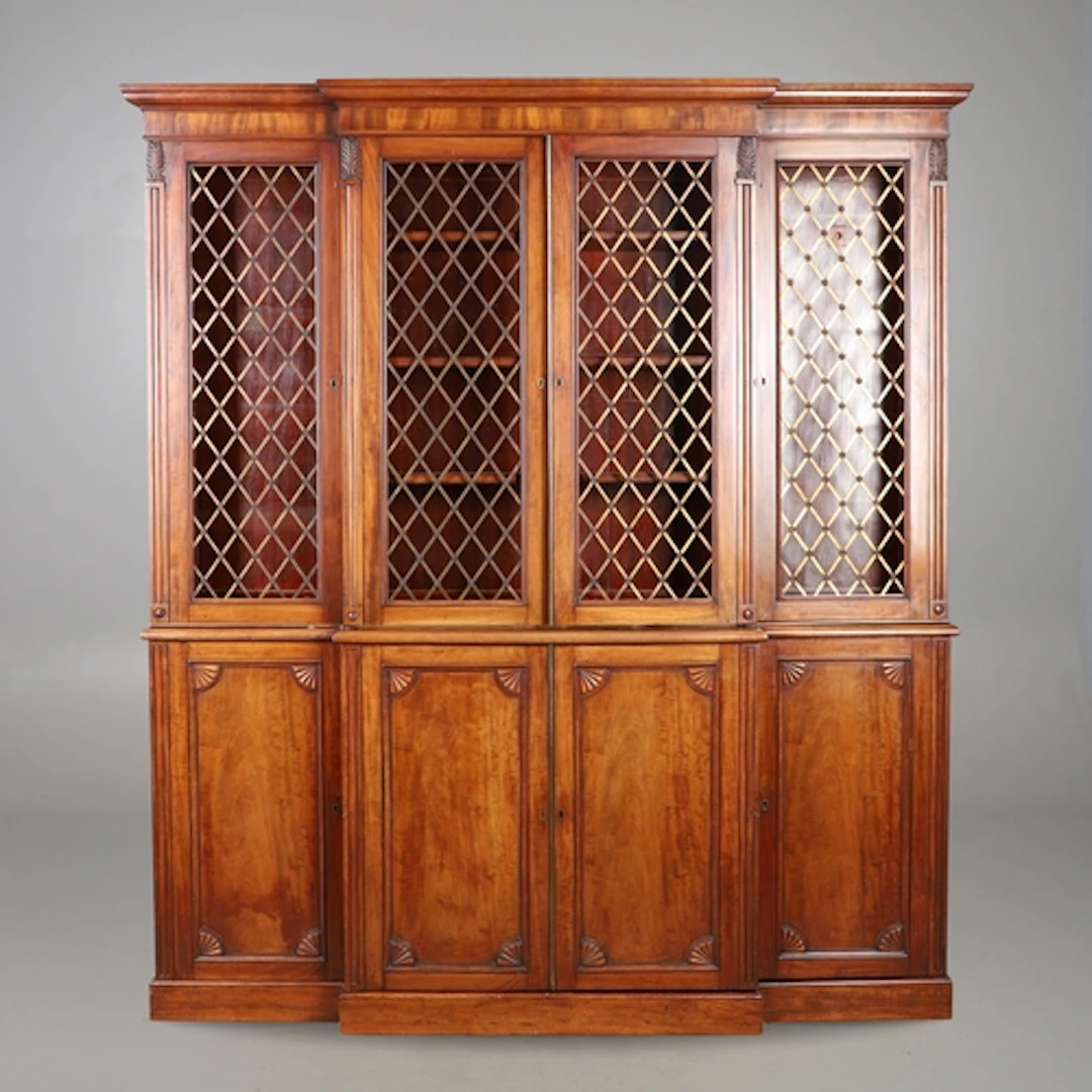 AN EDWARDIAN MAHOGANY BREAKFRONT BOOKCASE. the upper section...