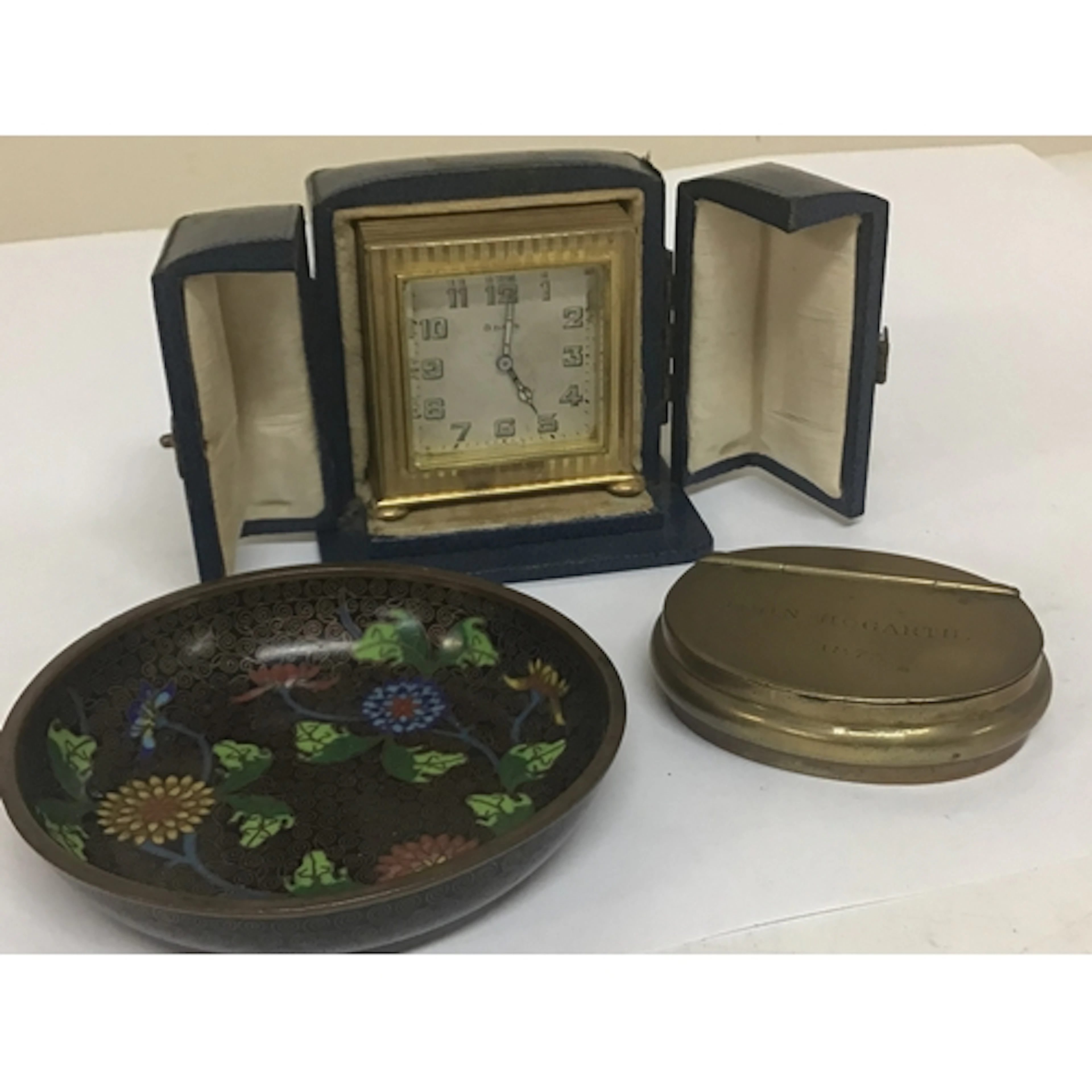 A small Swiss gilt cased travelling clock in a fitted ...
