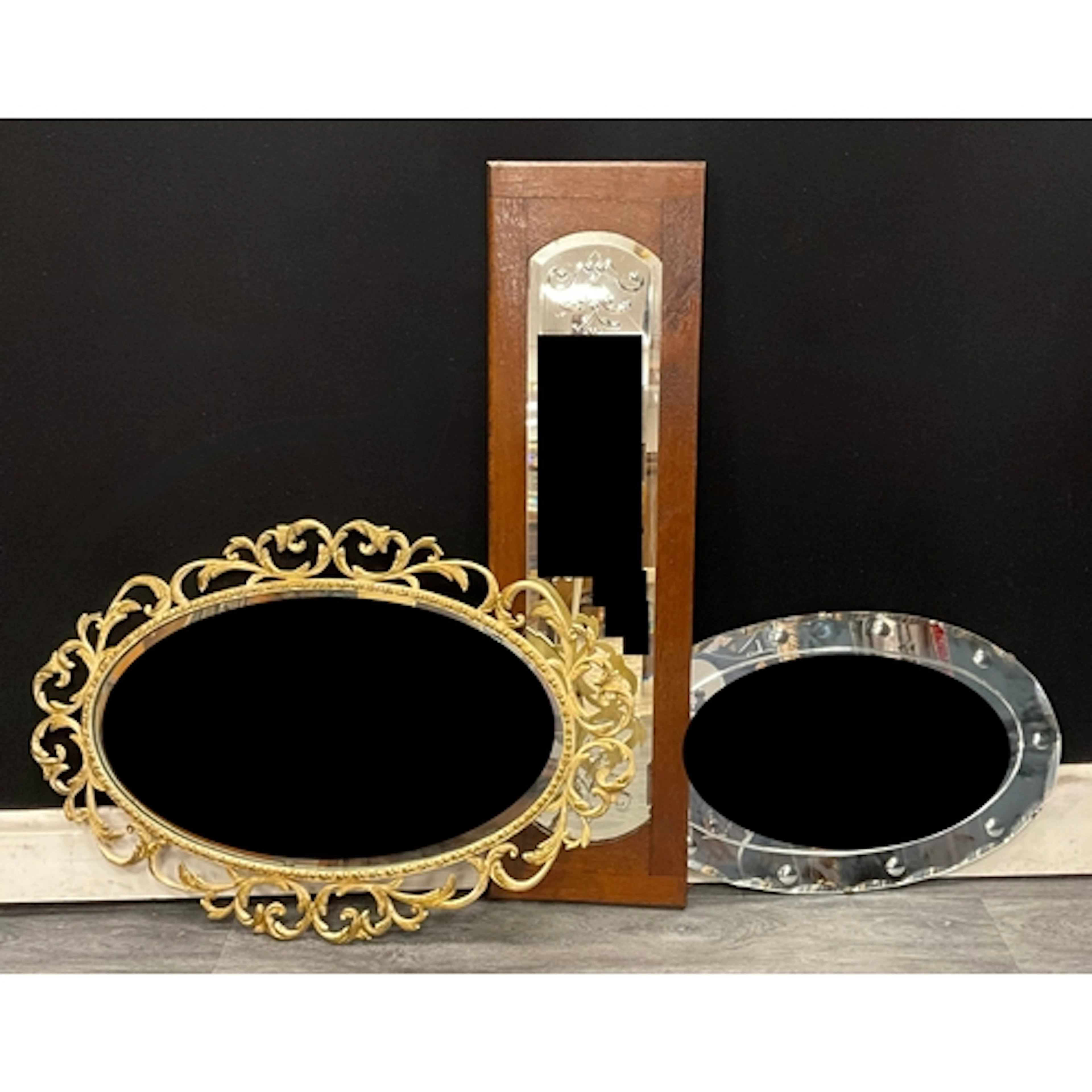 A trio of mirrors - a rococo revival oval gilt wall mirror; ...