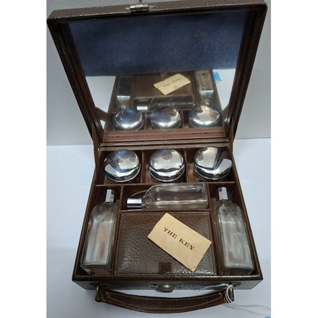 A brown grained leather vanity case having chrome topped gla...