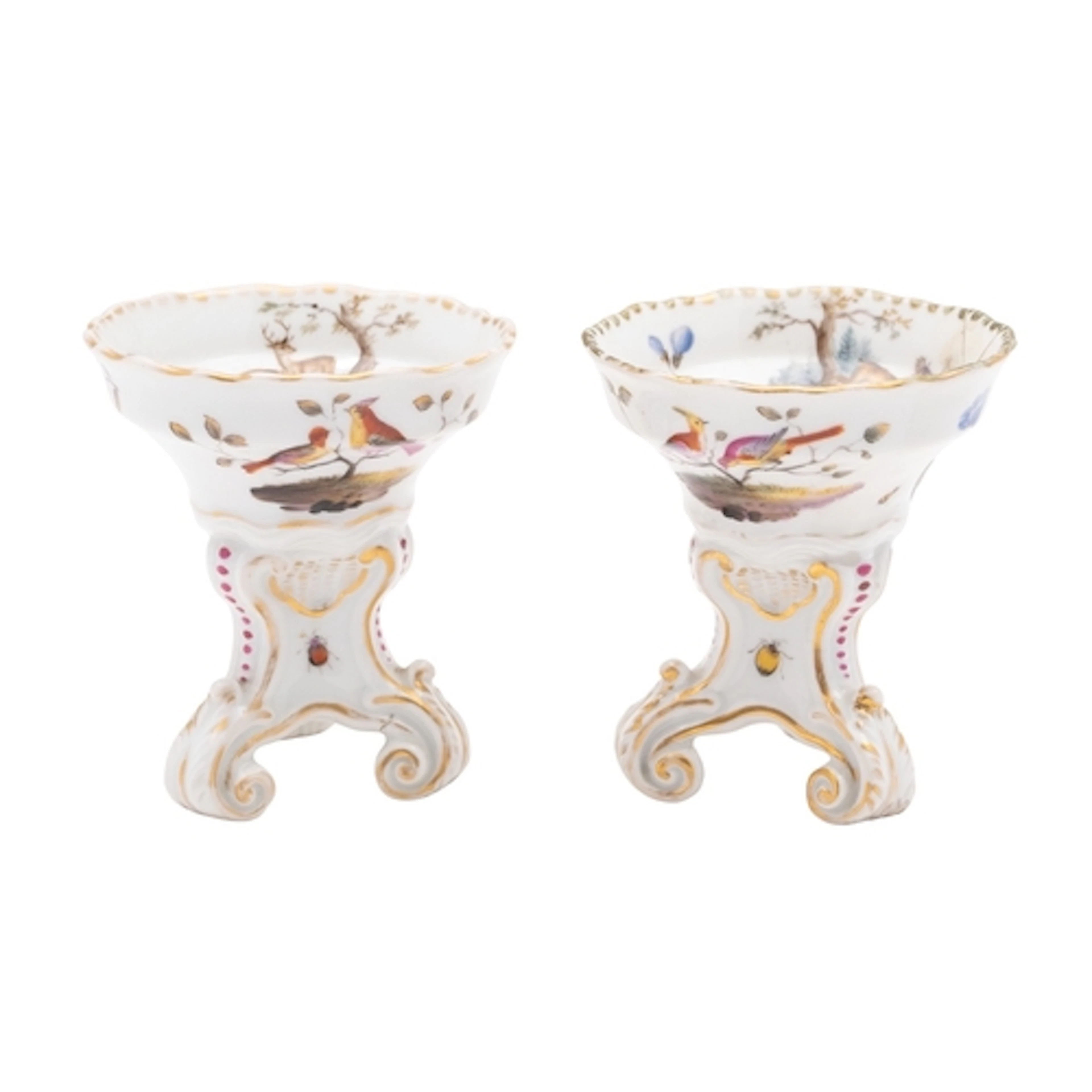 A pair of Meissen porcelain salts set on three scrolling fee...