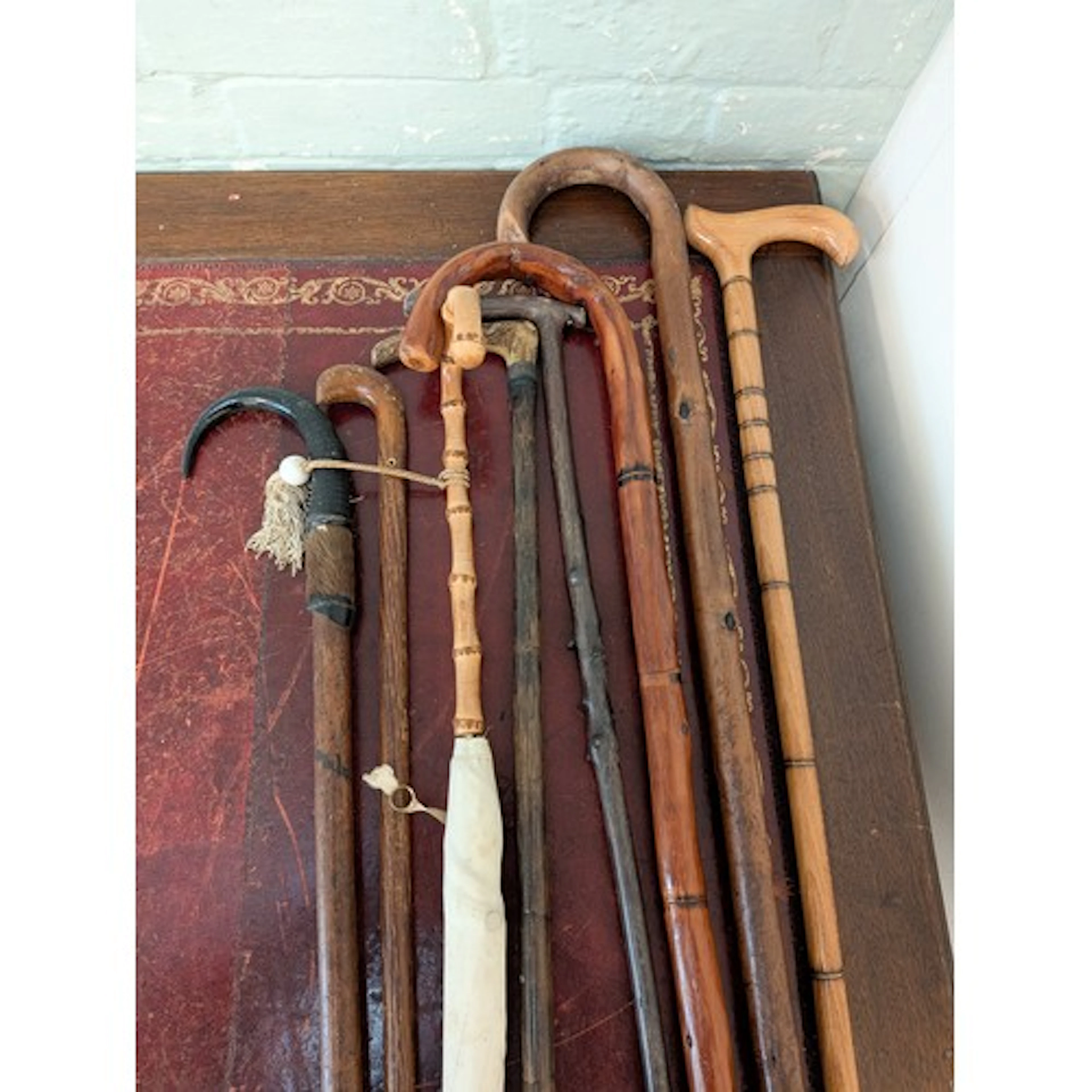 A collection of seven walking sticks, some with antler handl...