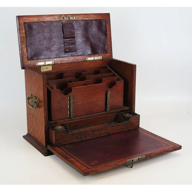 An Edwardian oak stationery box, the fall front with tooled ...
