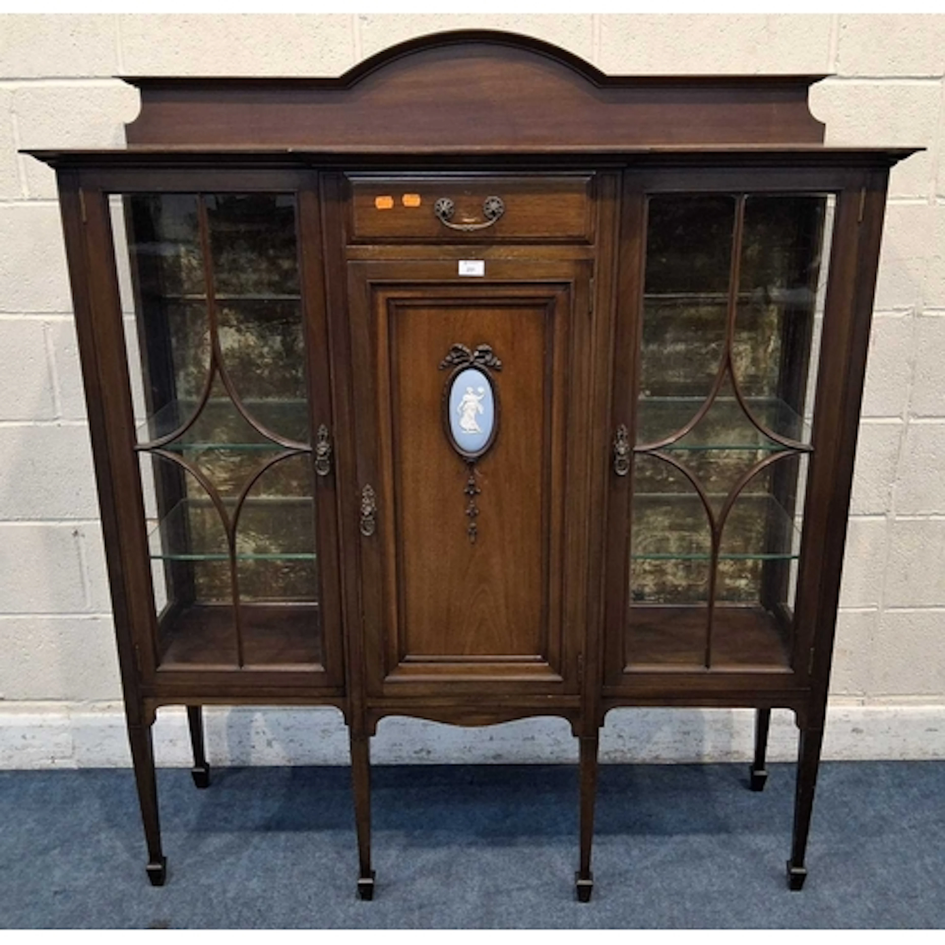AN EDWARDIAN MAHOGANY BREAKFRONT DISPLAY CABINET, with an ar...