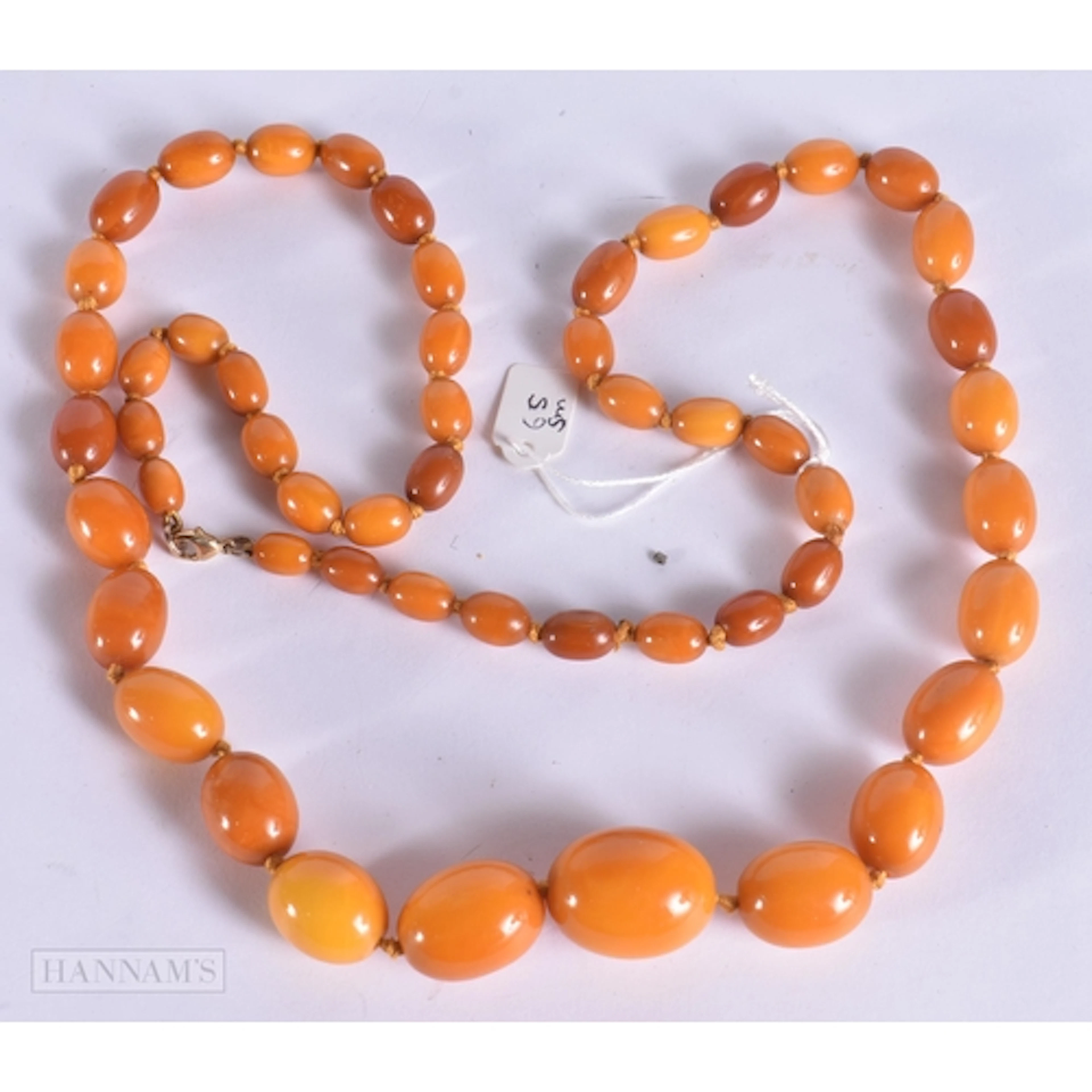 AN AMBER NECKLACE. 65 grams. 84 cm long, largest bead 2.75 c...