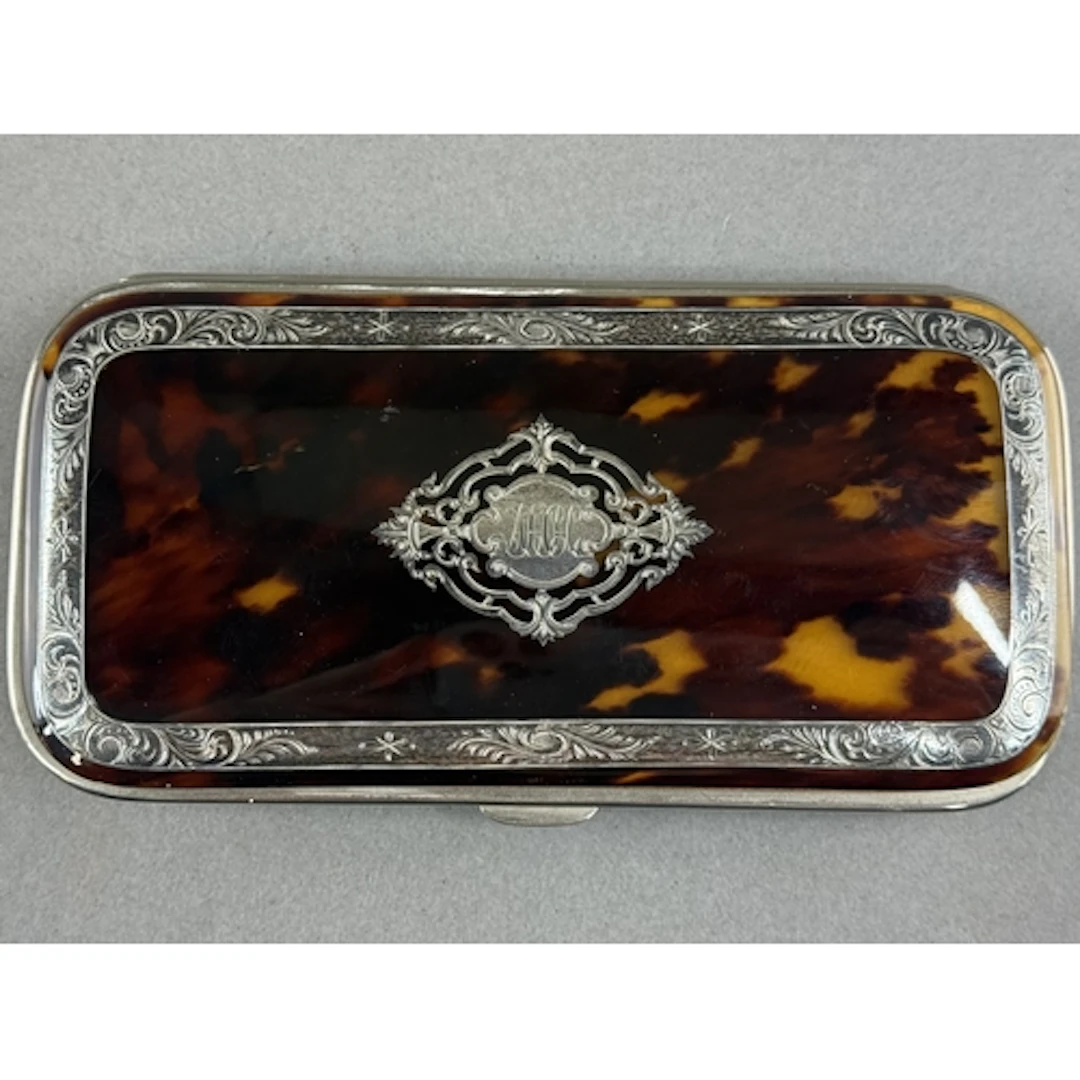 Decorative Arts: a late 19th century white metal inlaid tort...