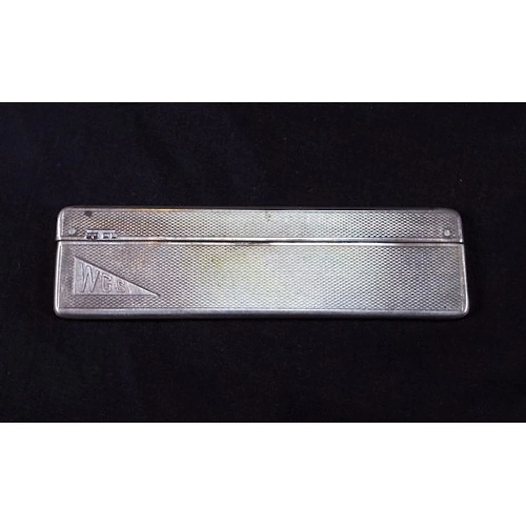 A hall marked silver Art Deco cased comb engine turned, weig...