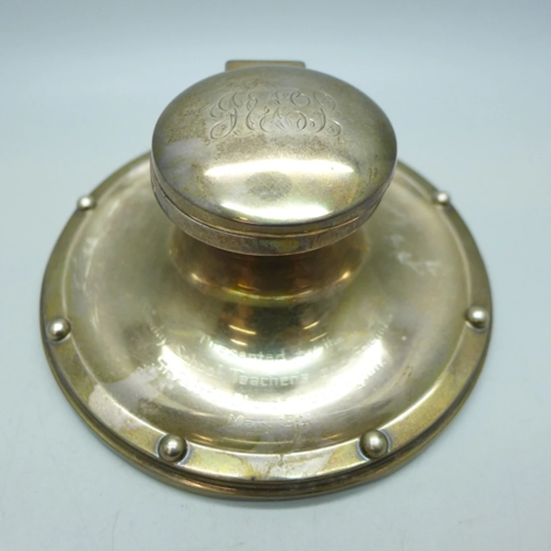 A George V silver capstan inkwell with monogram and inscript...
