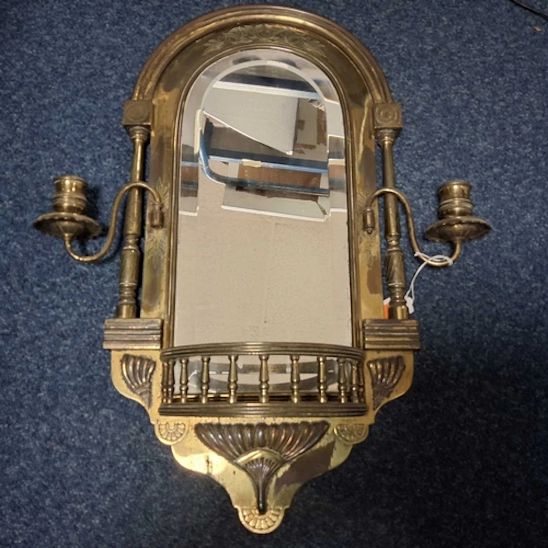 A WALL MOUNTED MIRROR WITH CANDLESTICKS comprising a brass m...