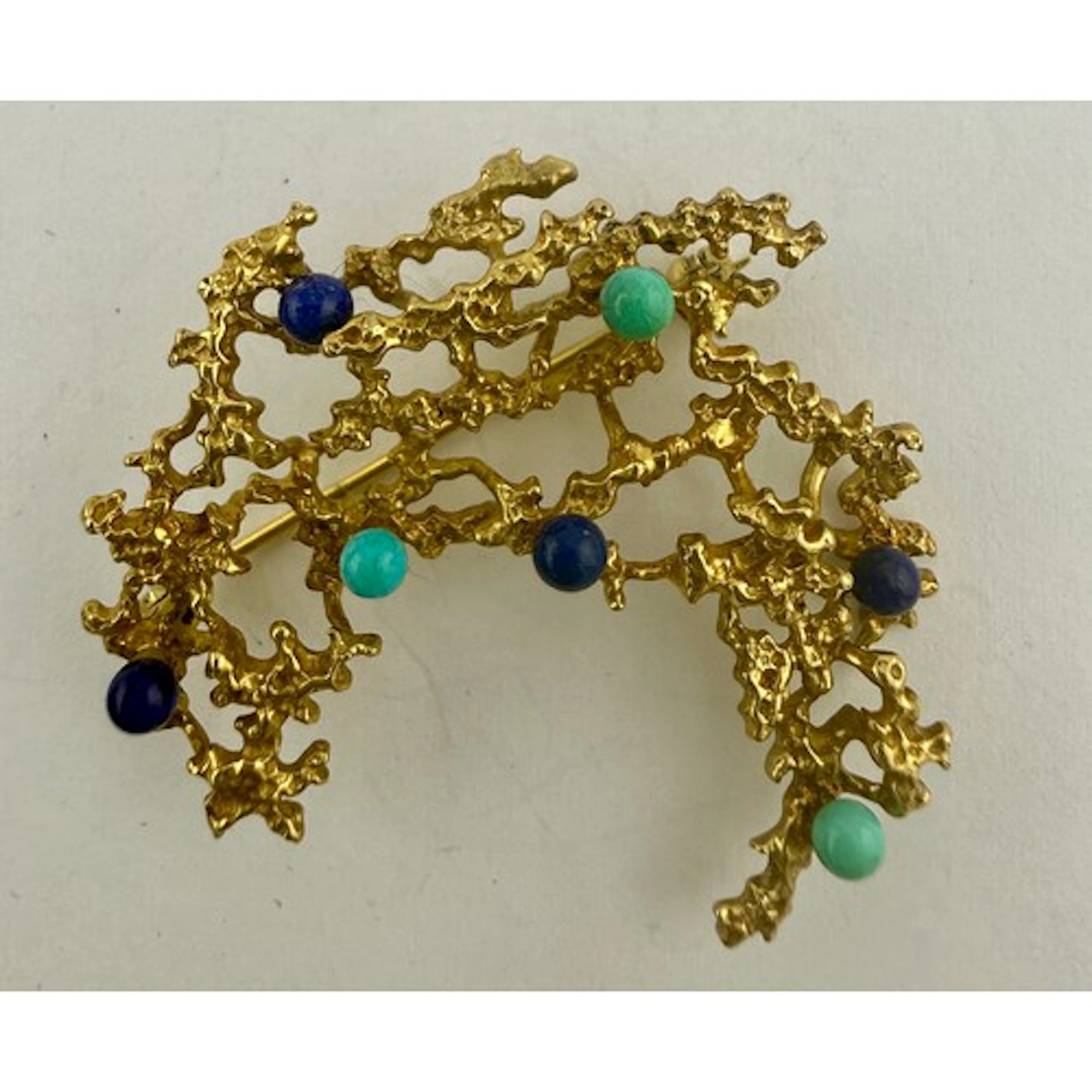 A mid 20thC 9 carat gold brooch set with dark and light blue...