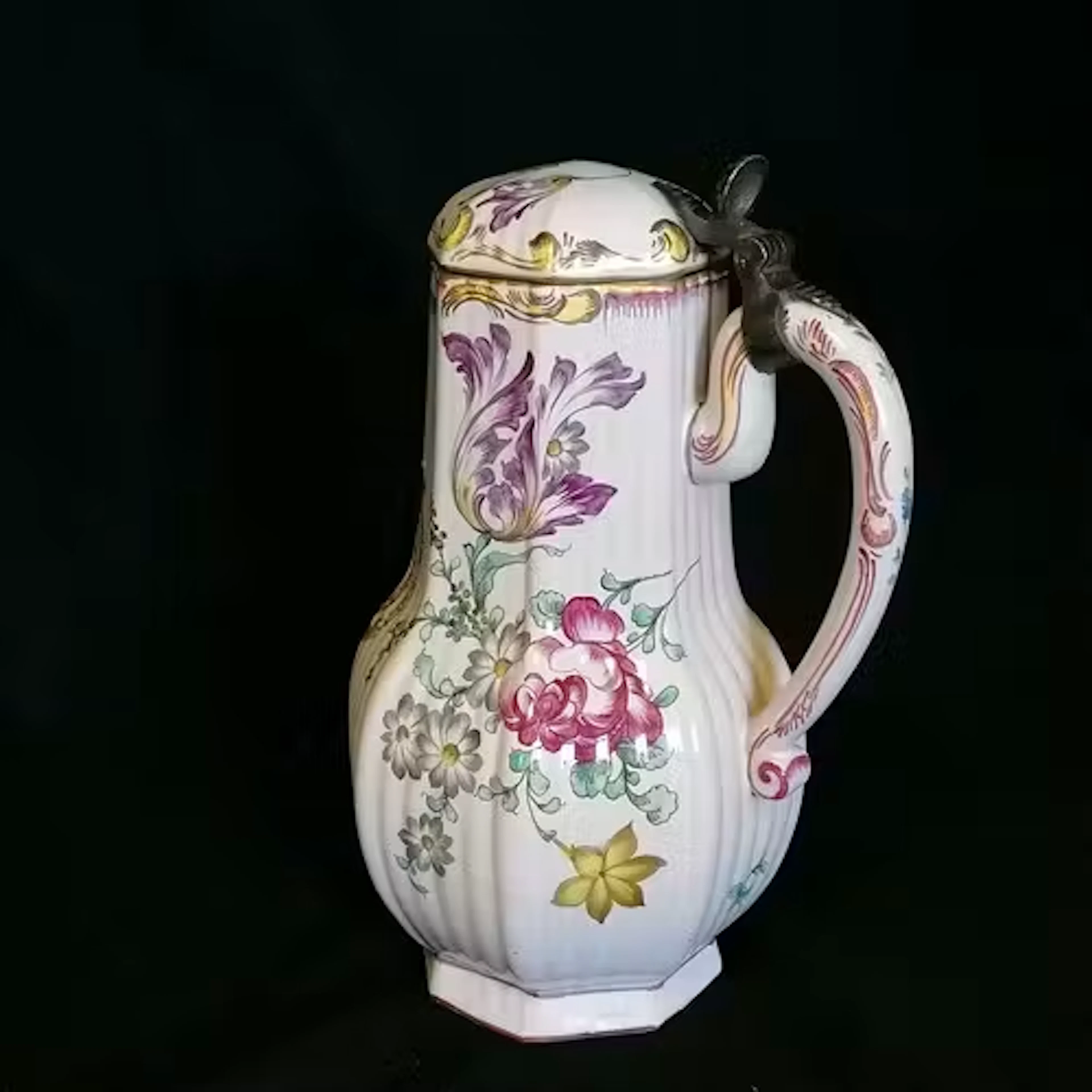 Faience floral decorated lidded jug with an armourial centre...