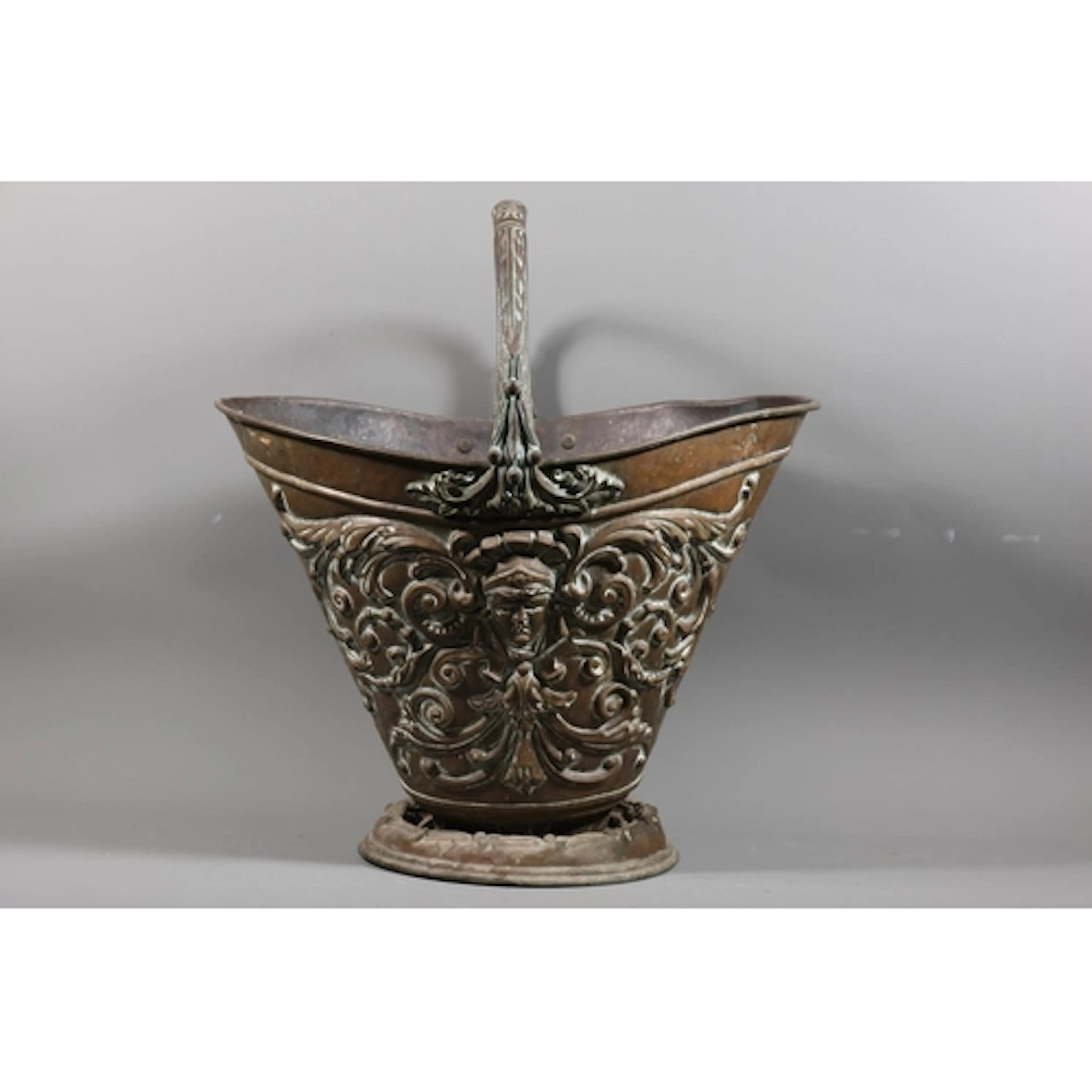 Brass coal bucket of tapering oval form decorated with masks...