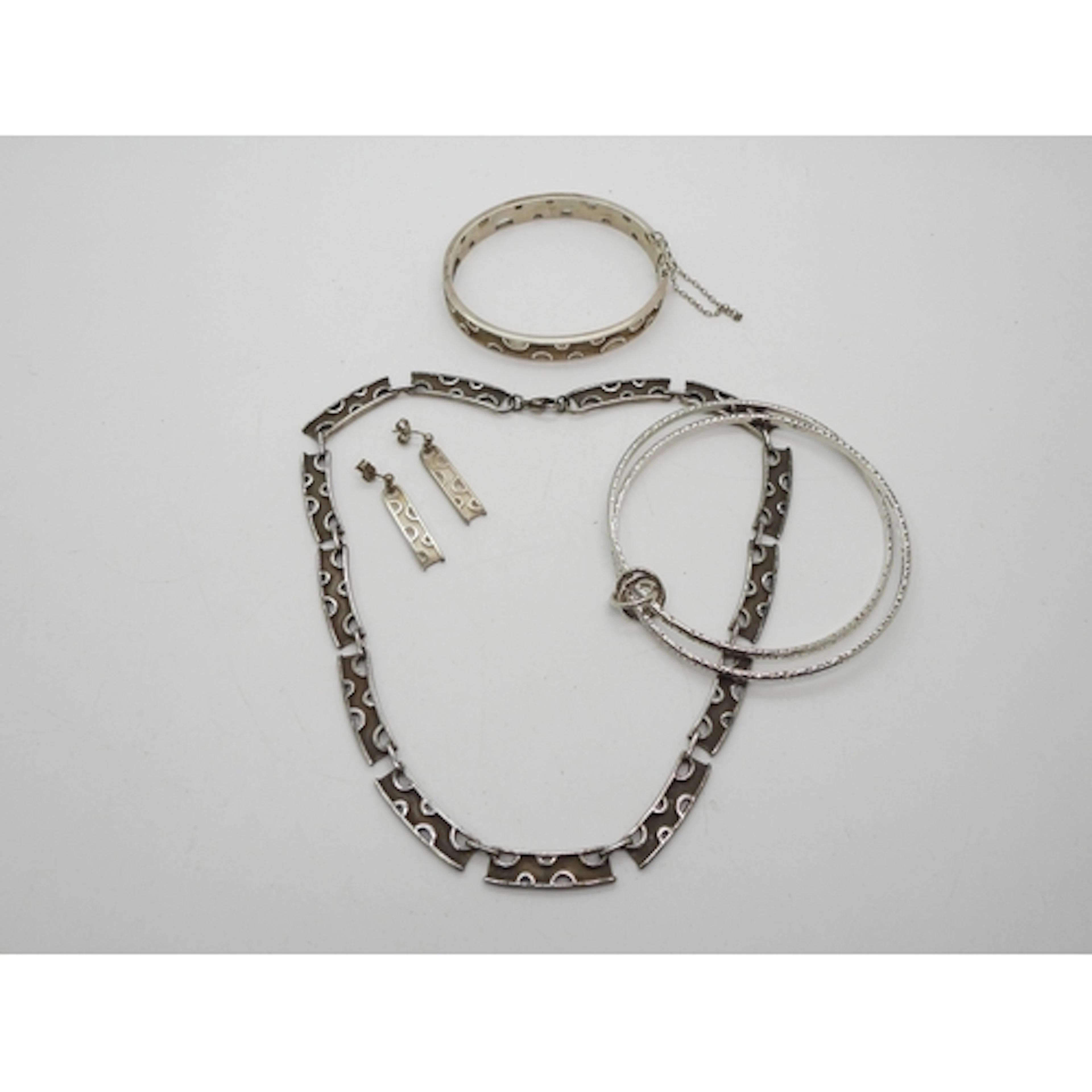 A silver necklace bangle and earrings set by Carrick, with p...