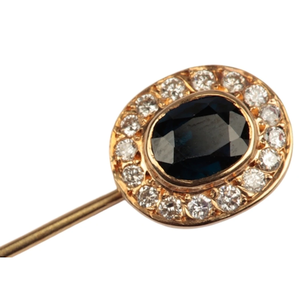 A sapphire and diamond stick pin, of cluster design, set wit...