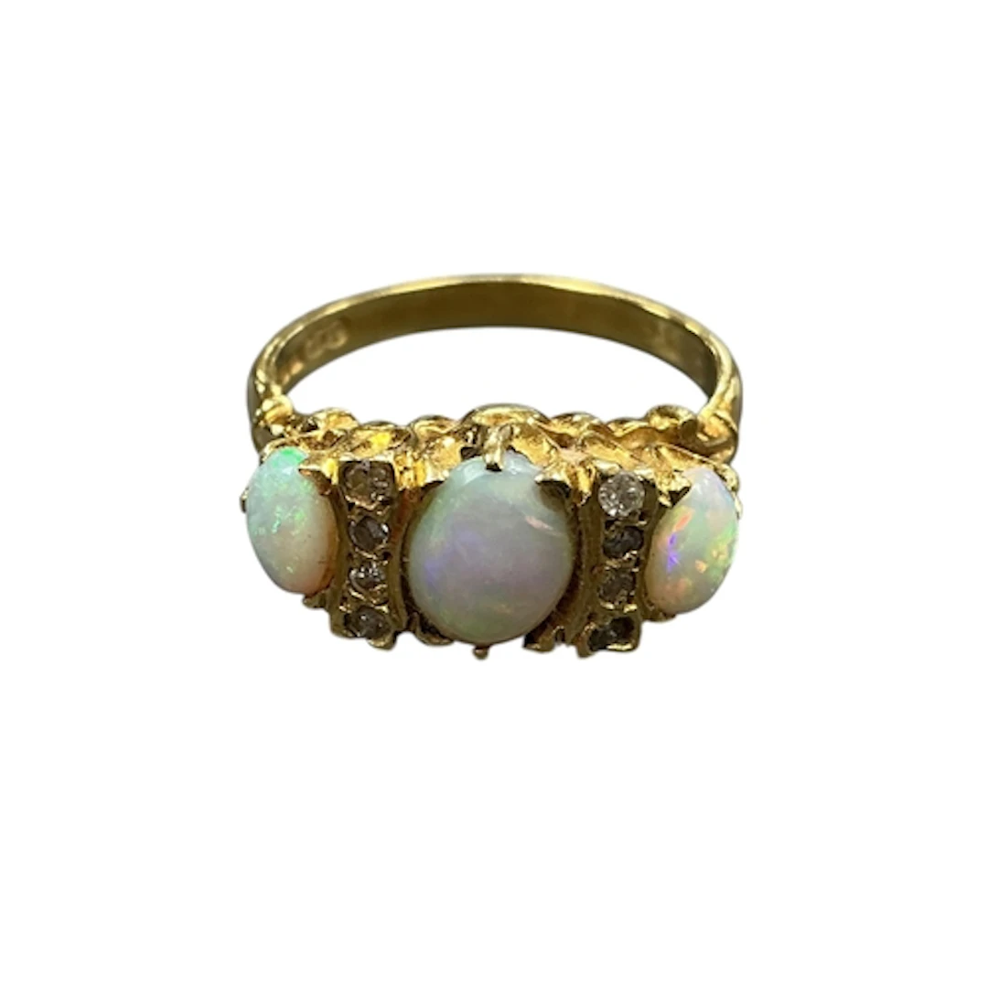 A 1970's 18ct gold and three stone white opal ring, with eig...