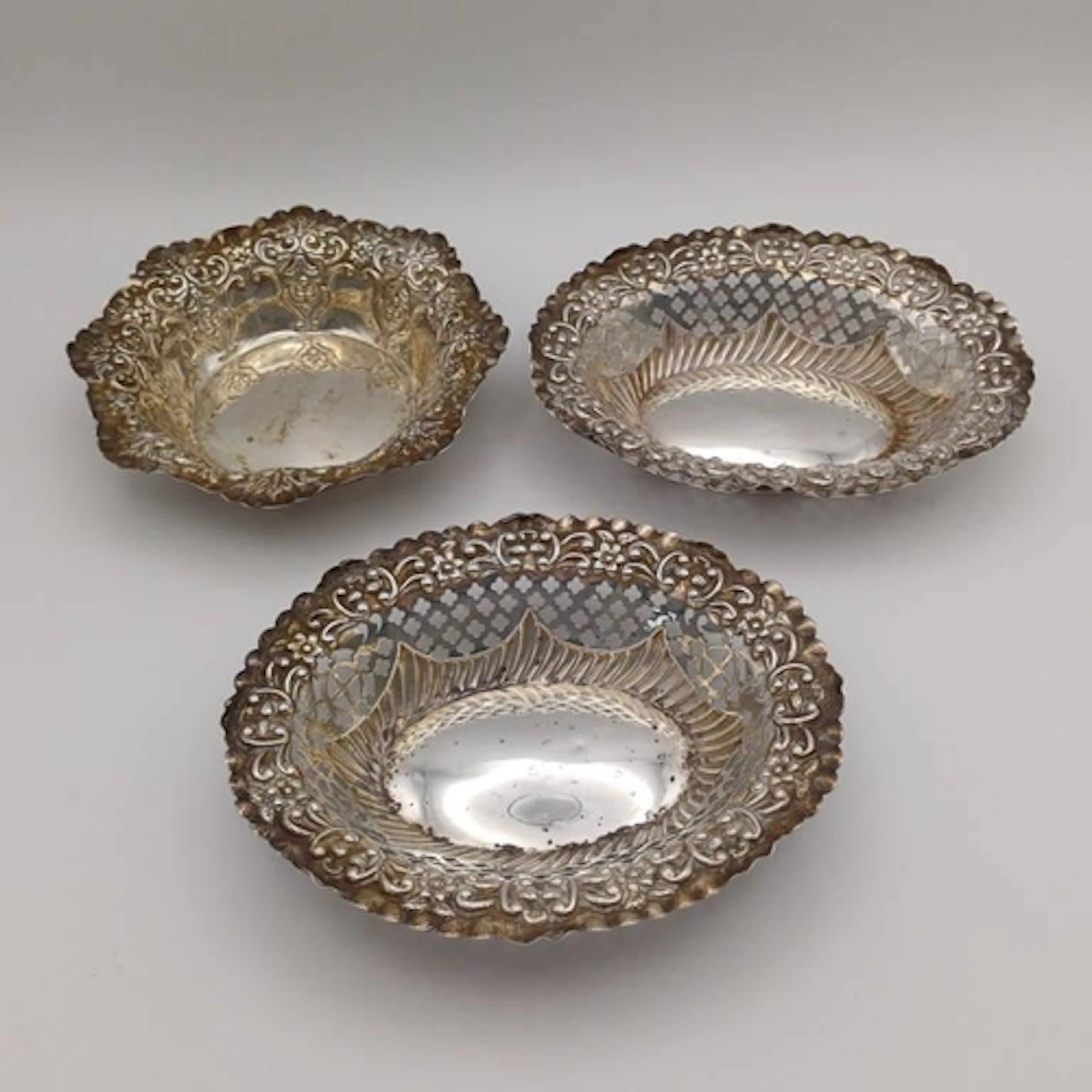A PAIR OF SILVER PIN DISHES WITH PIERCED & EMBOSSED DECORATI...