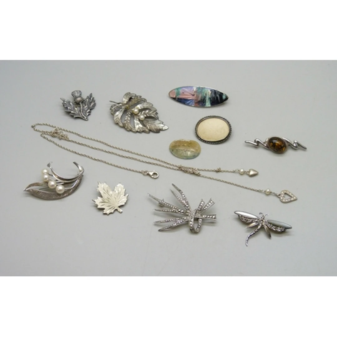 A collection of silver brooches, painted brooch a/f, and a s...