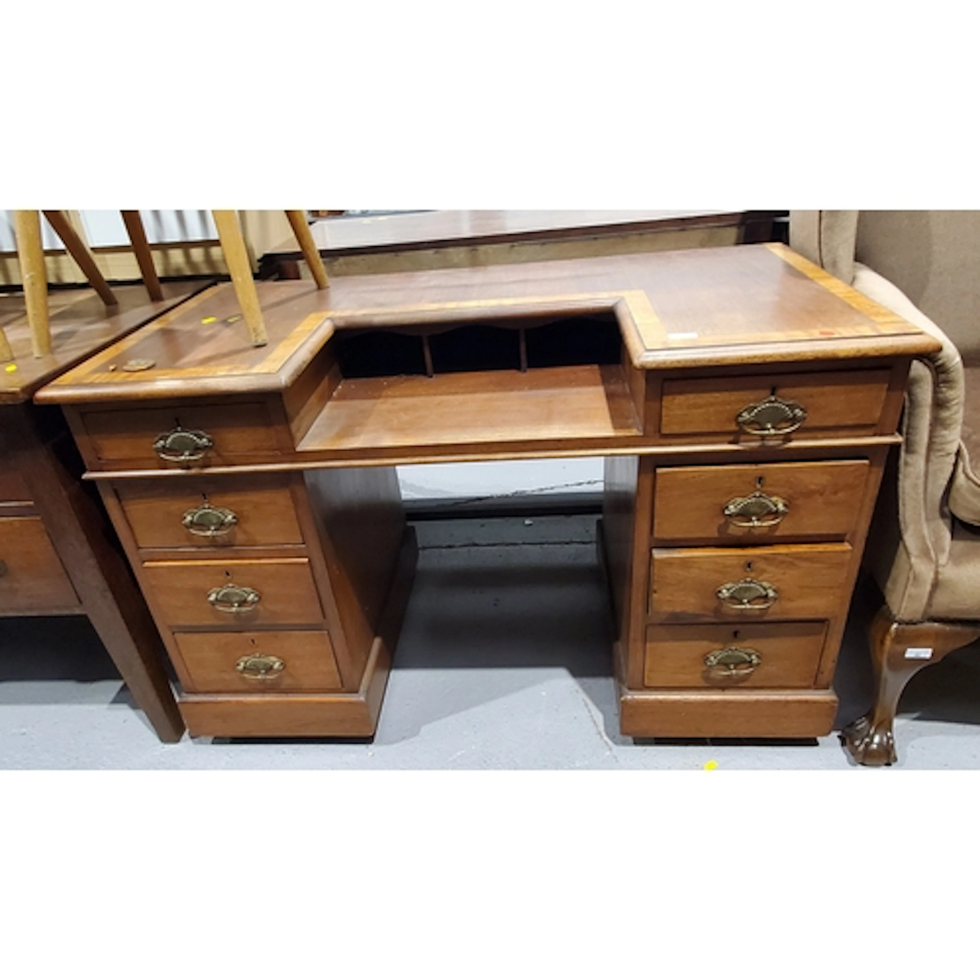 A crossbanded Desk eight drawers raised on a plinth base wit...