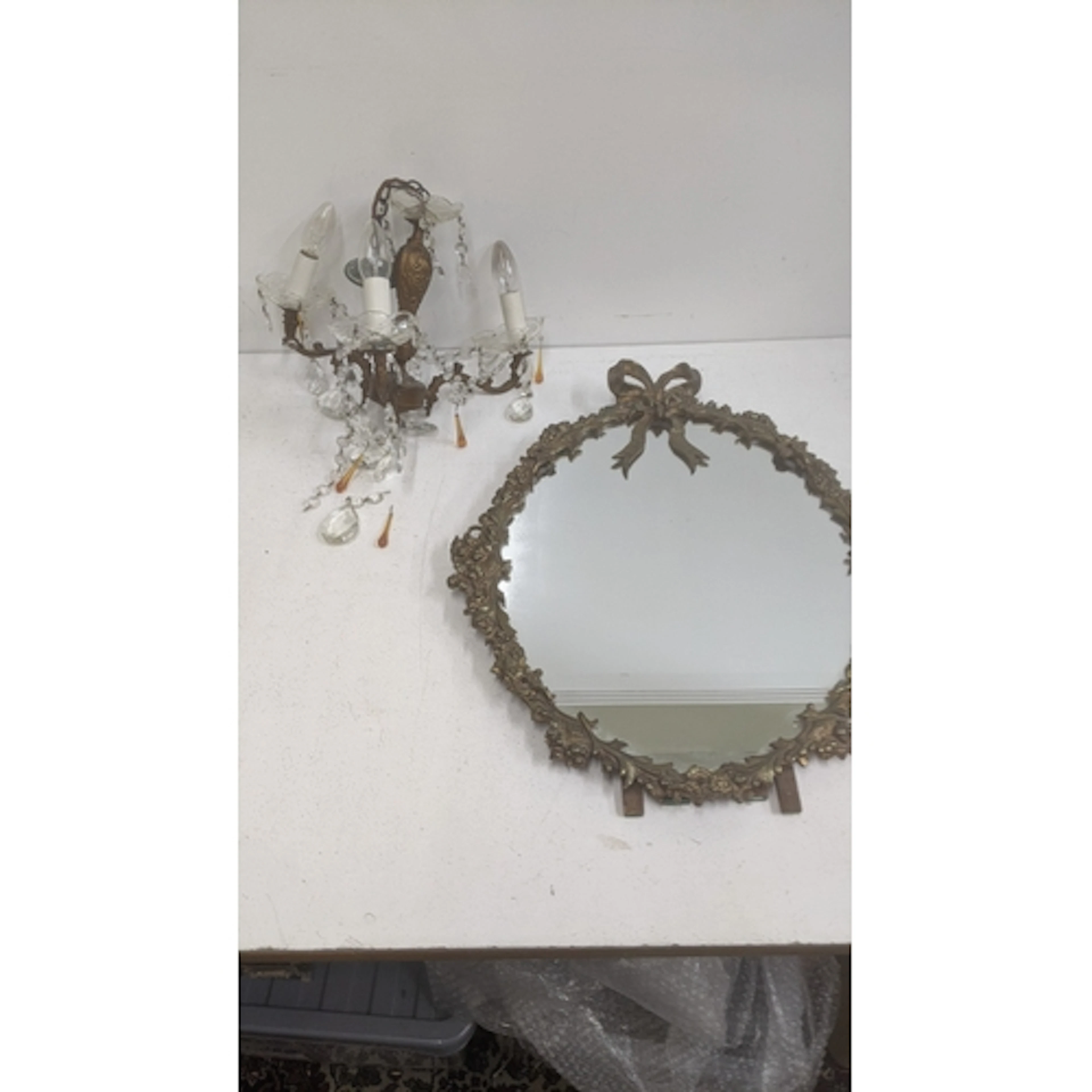 A vintage oval mirror with a brass decorative frame, along w...