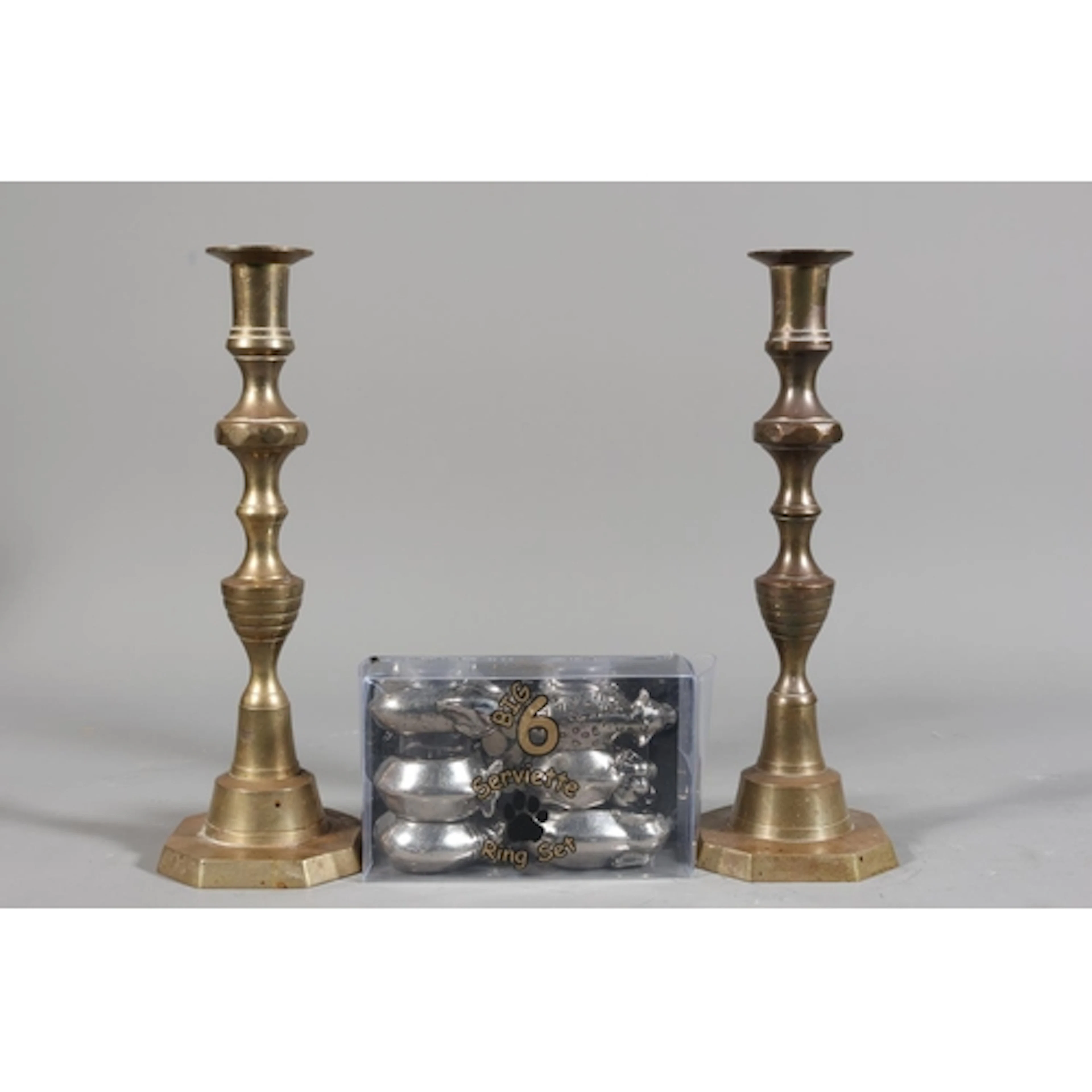 Pair of brass candlesticks and a set of napkin rings modelle...