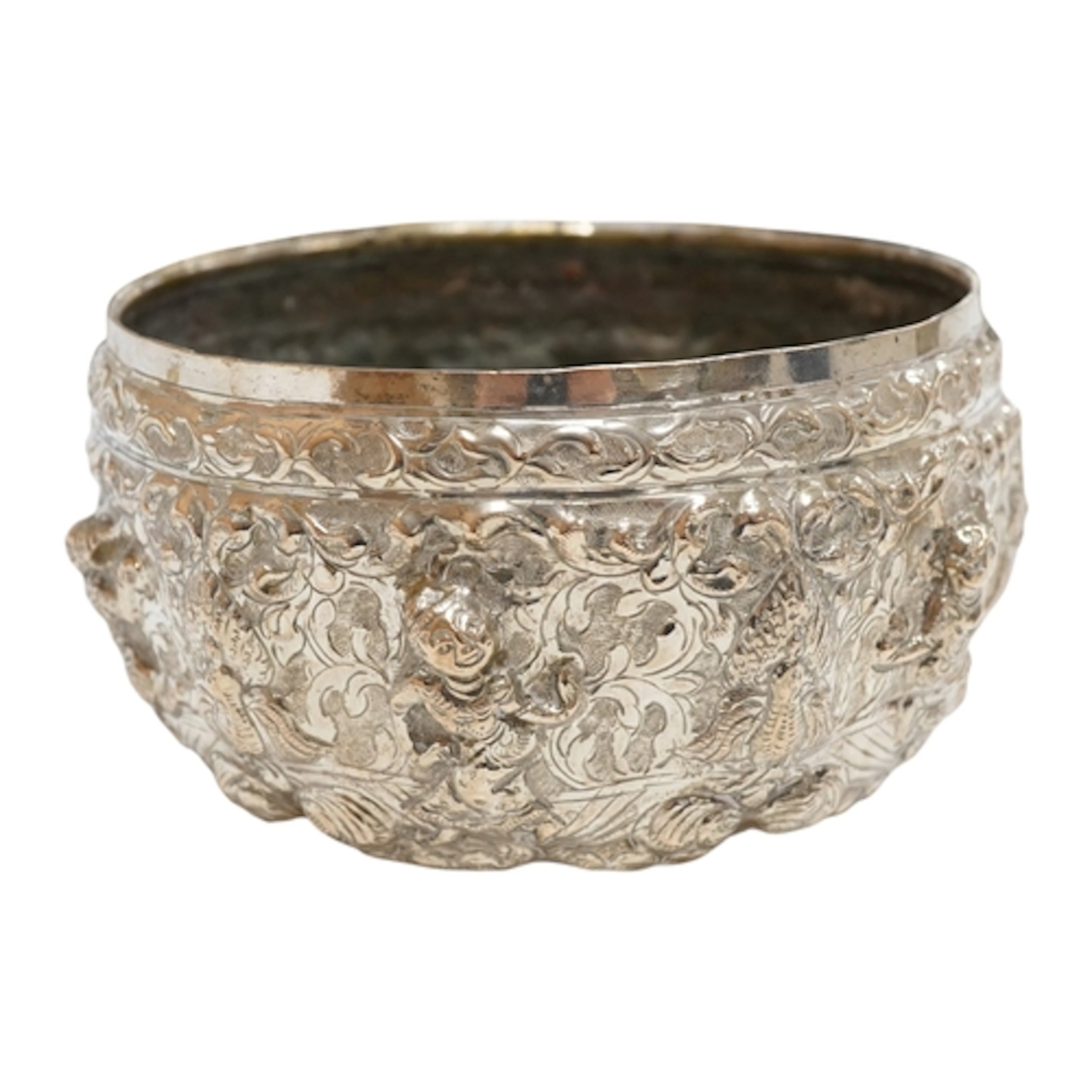 A Burmese repousse white metal bowl, decorated with figures ...