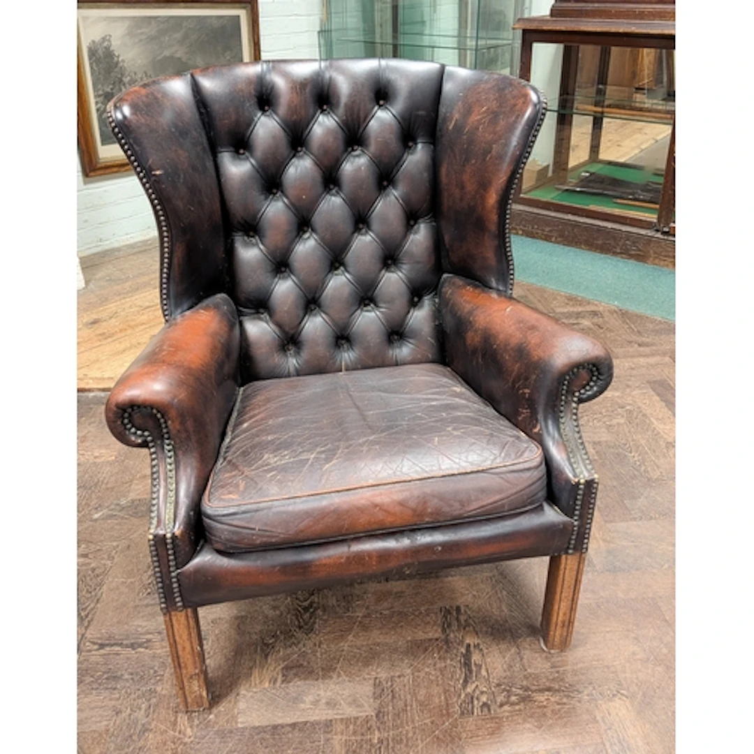 A Georgian style buttoned wing back easy chair in leather