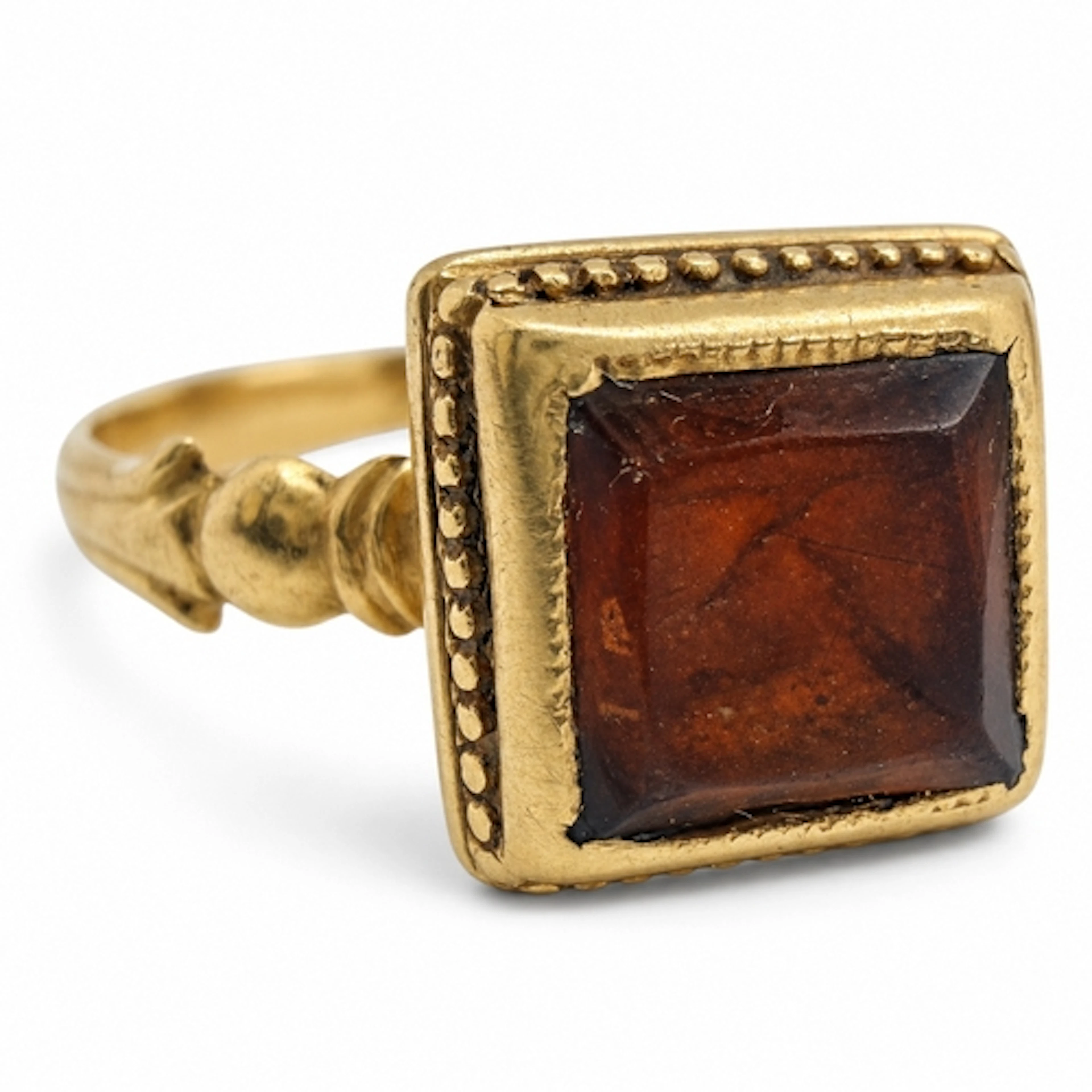 A gold ring, centred by a rectangular table-cut hessonite ga...