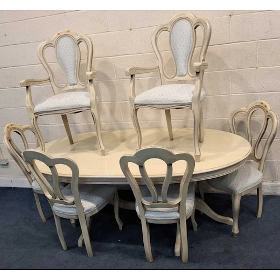 A CREAM OVAL DINING TABLE, raised on twin bulbous pedestals ...