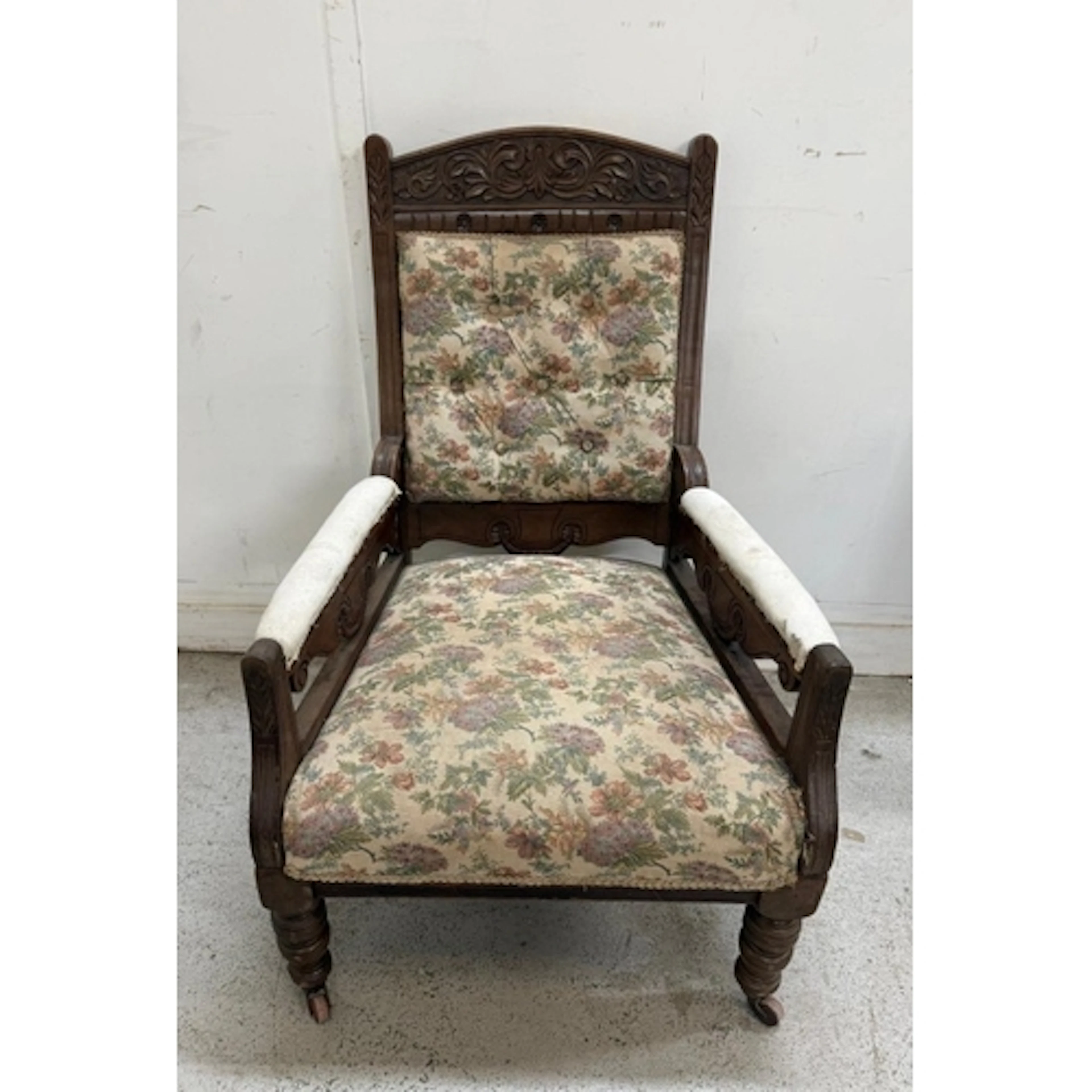 An oak framed button backed armchair on casters with floral ...