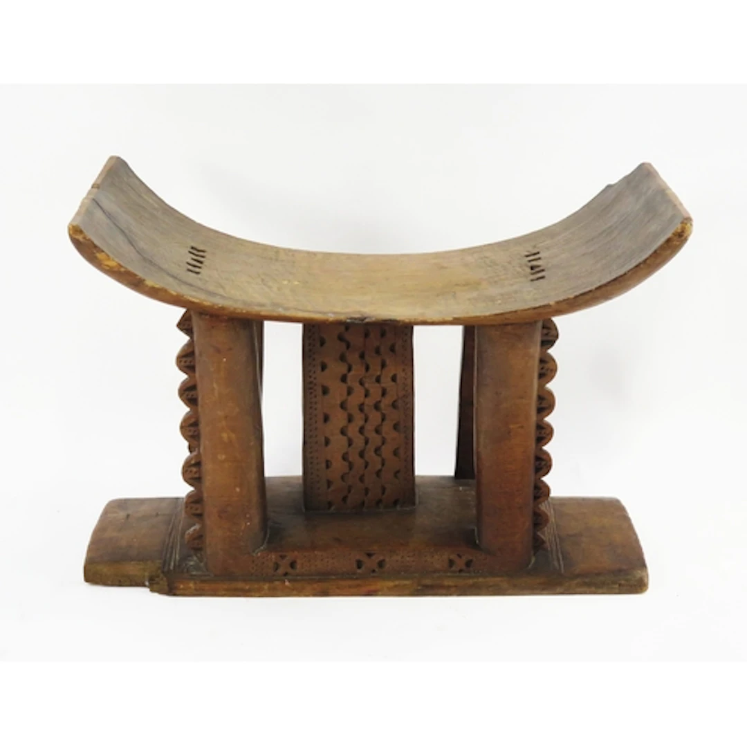 A hardwood Ashanti stool, with curved seat on block supports...